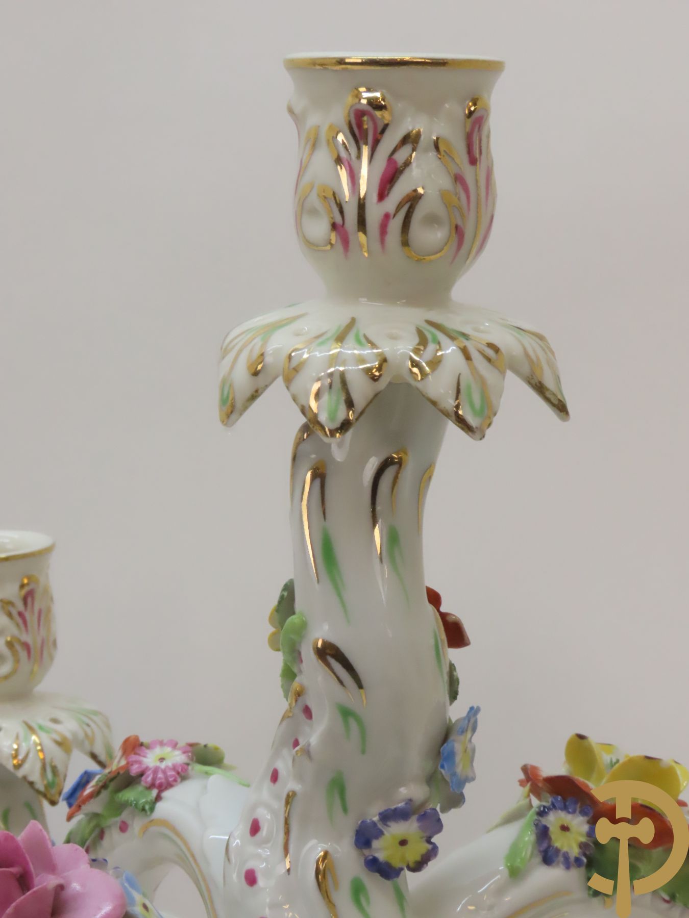 Twee porseleinen vijfarmige kandelaars met cupido