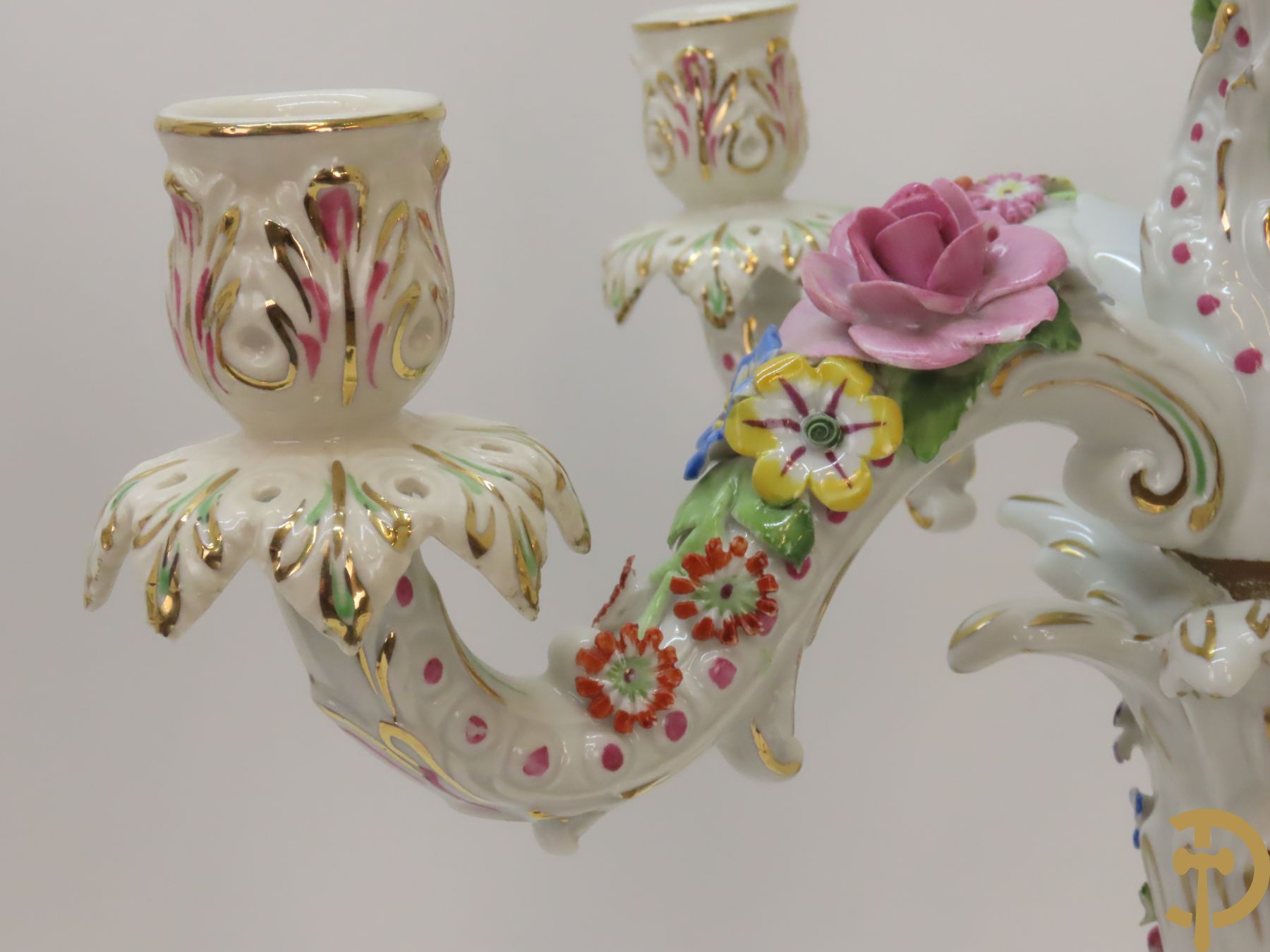 Twee porseleinen vijfarmige kandelaars met cupido