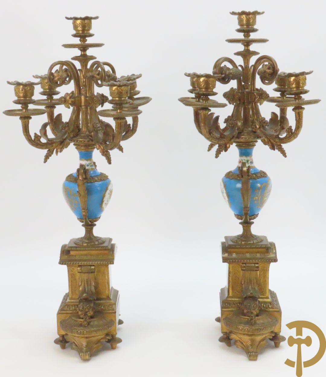 Driedelige bronzen garnituur bezet met Sèvres porselein bestaande uit pendule geflankeerd door paar cupido