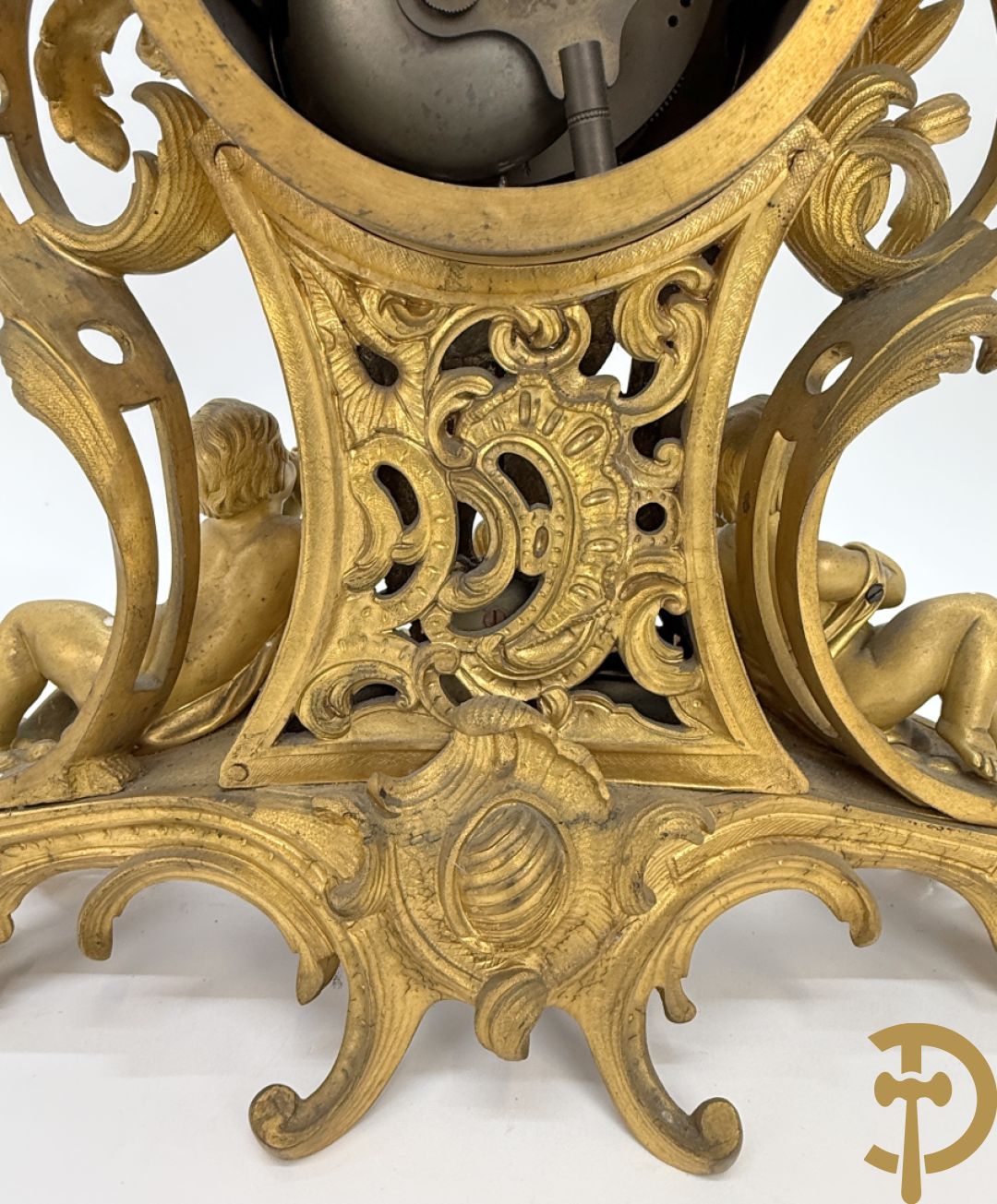 Driedelige vuurvergulde bronzen garnituur, Louis XV stijl, bestaande uit middenstuk met klok omgeven door musicerende cupido