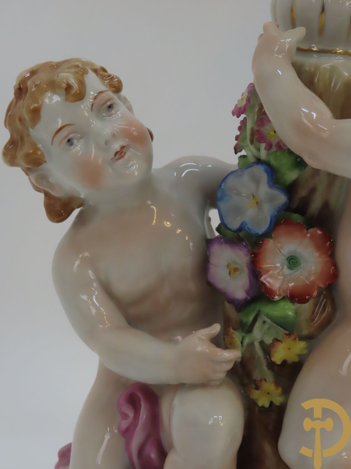 Twee porseleinen vijfarmige kandelaars met cupido