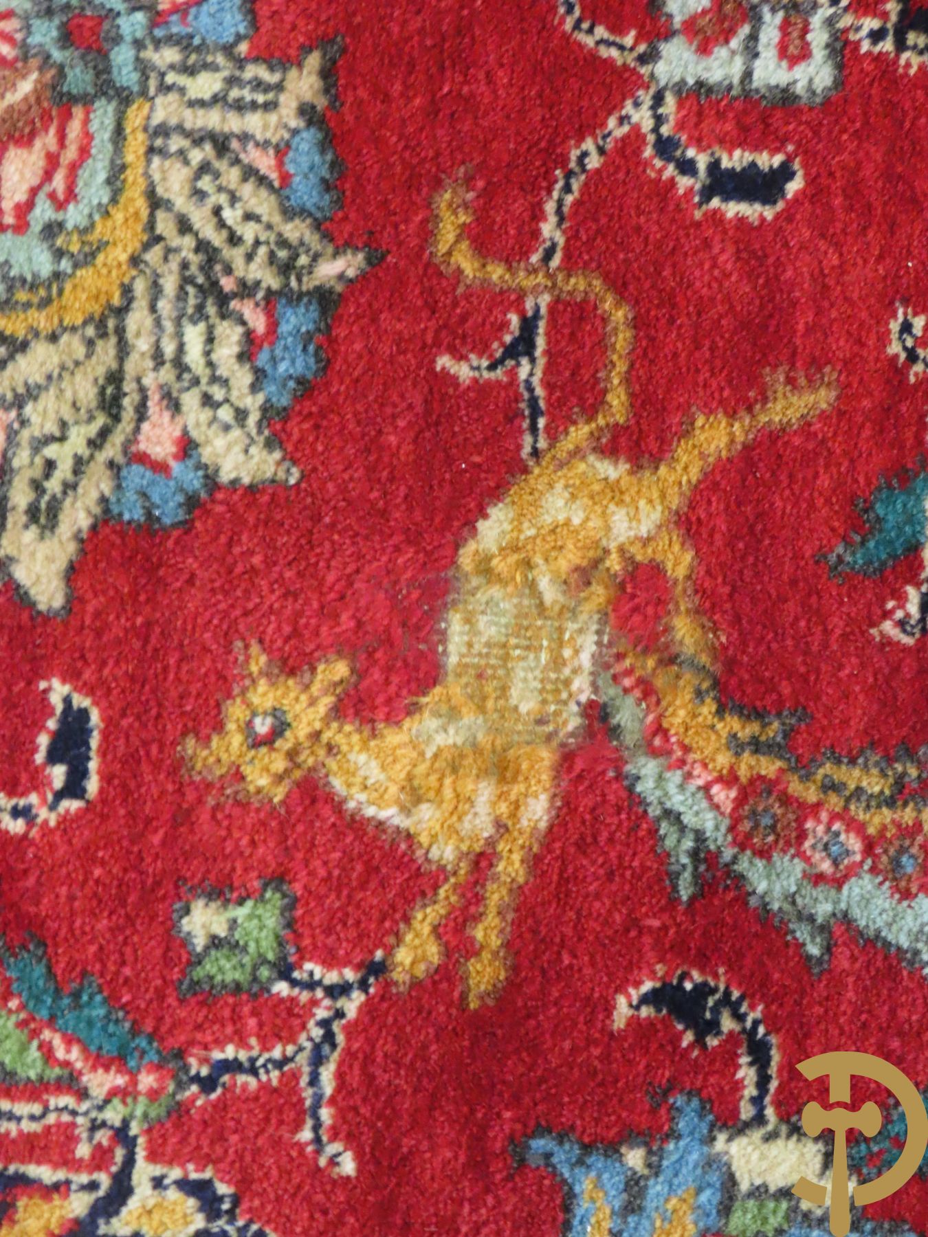 Oosters handgeknoopt tapijt met bloemen, dierenmotieven en centraal decor op rode fond