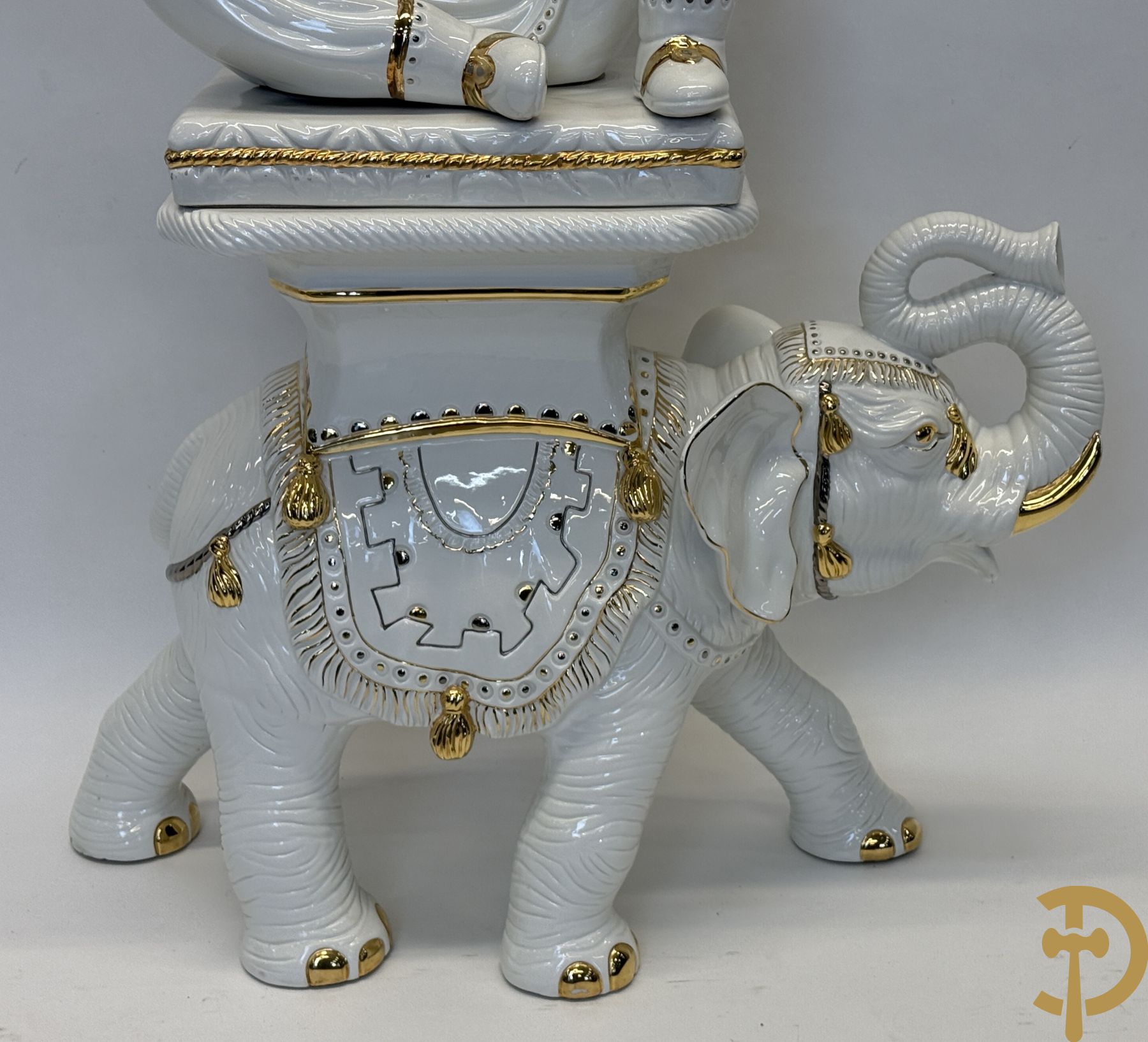 Porseleinen sierbeeld van olifant als staander met daarboven jongeman met bloemencachepot