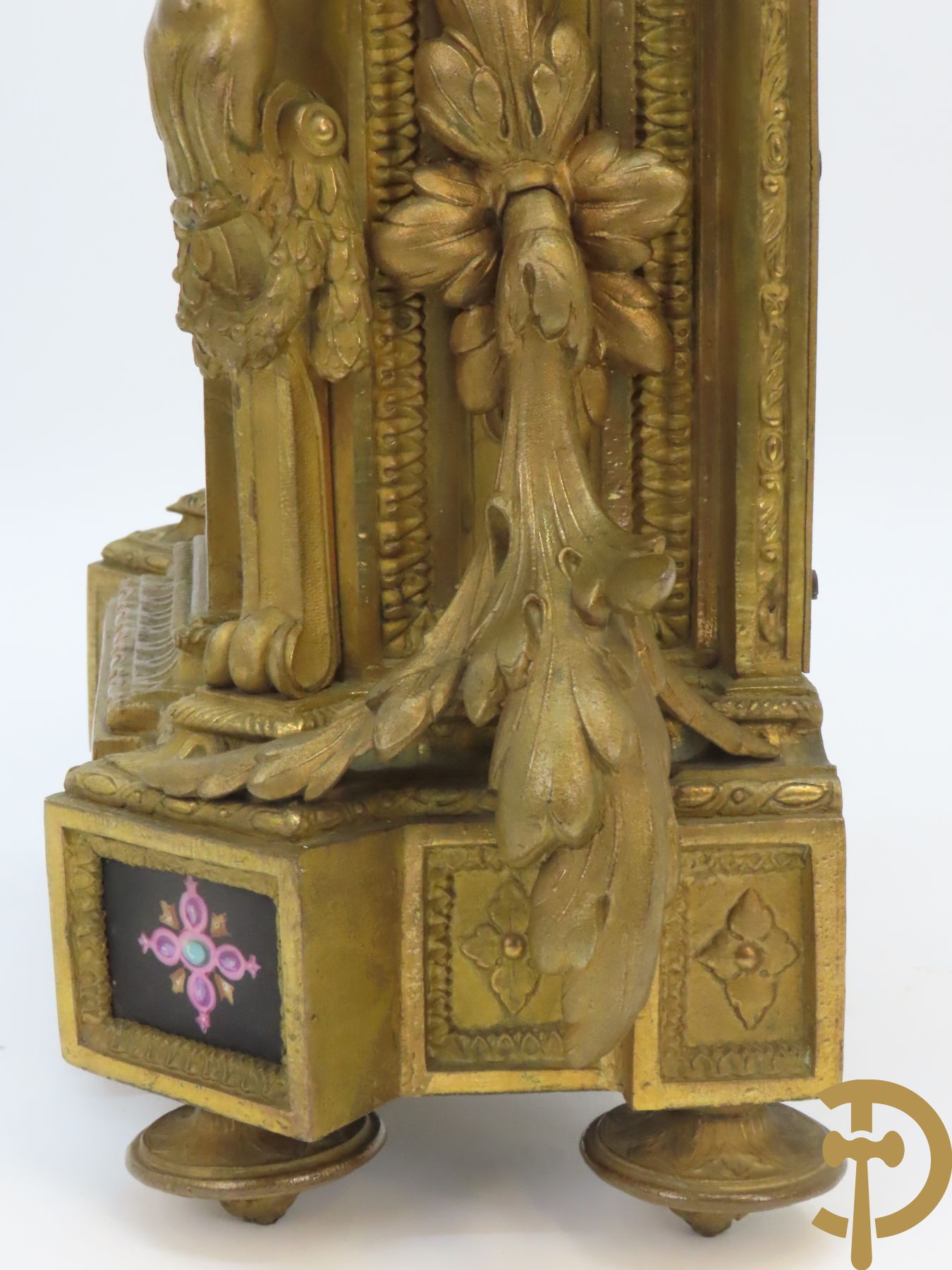 Vergulde pendule in zamak, wijzerplaat bezet met porseleinen plakkettes - bovenaan met vogelpaar, zijdelings met kariathyden houdende een bloementroffee - onder glazen stolp