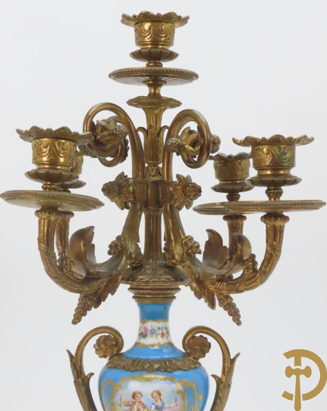 Driedelige bronzen garnituur bezet met Sèvres porselein bestaande uit pendule geflankeerd door paar cupido