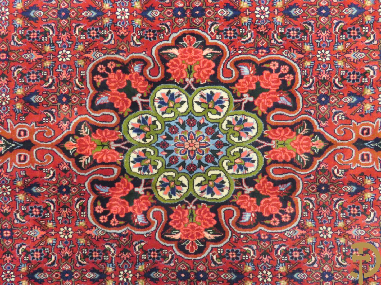 Oosters handgeknoopt tapijt met bloemenpatronen op rode fond