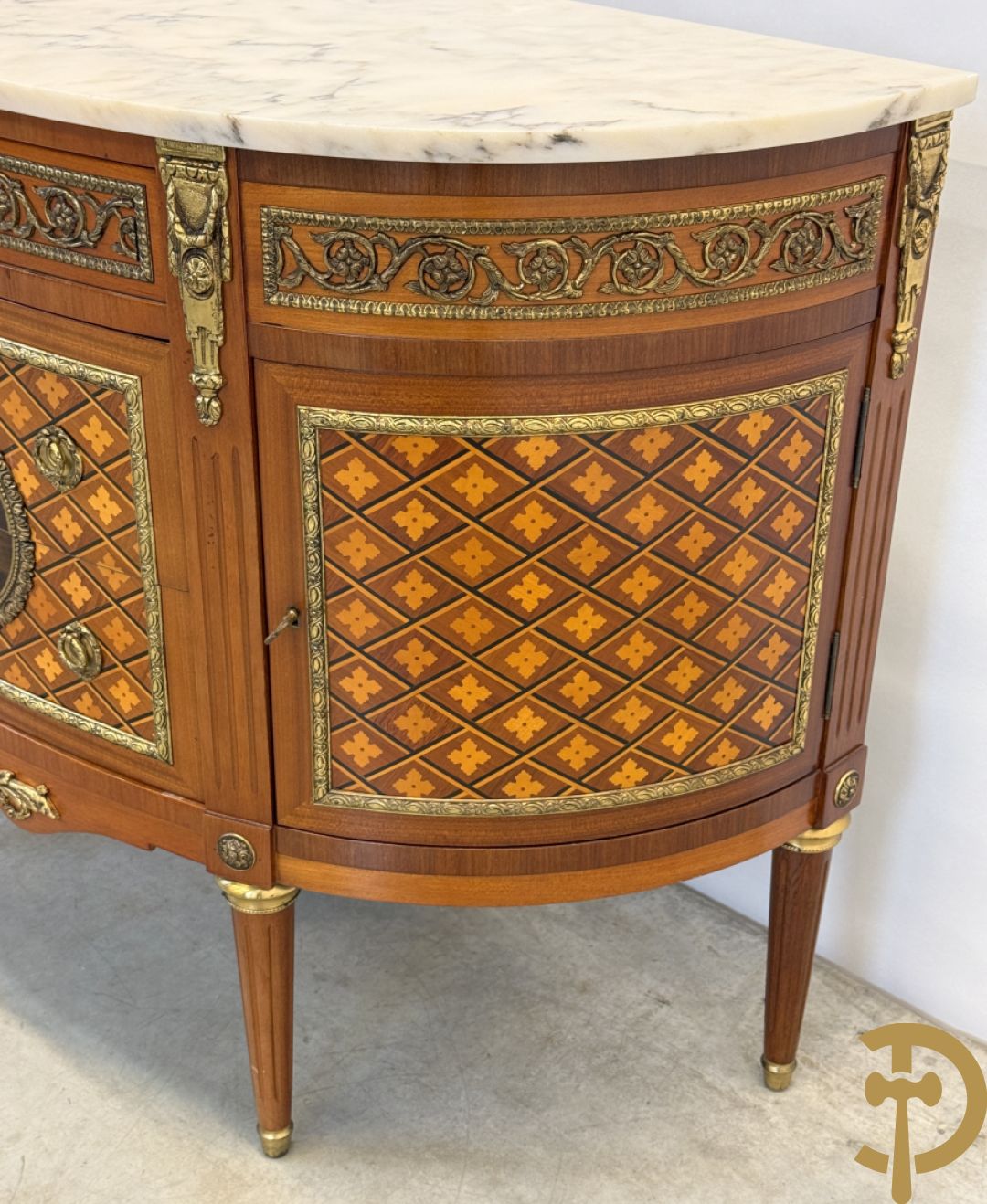 Halve maanvormige drieladencommode met 2 zijdelingse deuren, gemarketteerde bloemenmotieven en bronzen ornamenten, bovenaan bezet met marmeren blad