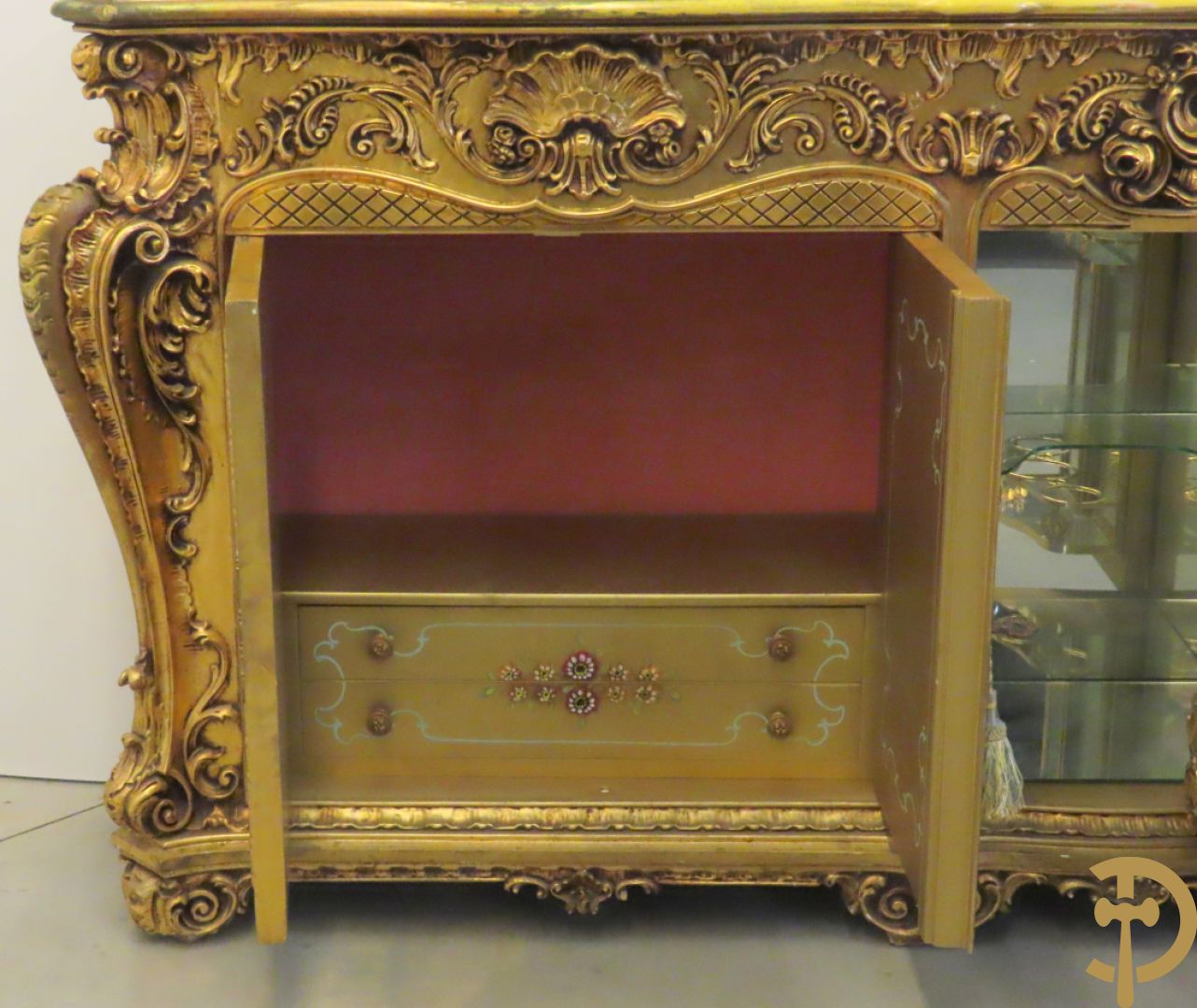 Uitzonderlijke vergulde Louis XV eetkamer bestaande uit vijfdeursdressoir met voluutvormige accanthusranken en rocailles, beschilderd met bloemenmotieven en centraal tafererel met hoornen des overvloeds + bijhorende spiegel vergulde tafel op voluutvormige poten met zes bijhorende stoelen + vitrine met accanthusranken en centrale deur, op voluutvormige poten