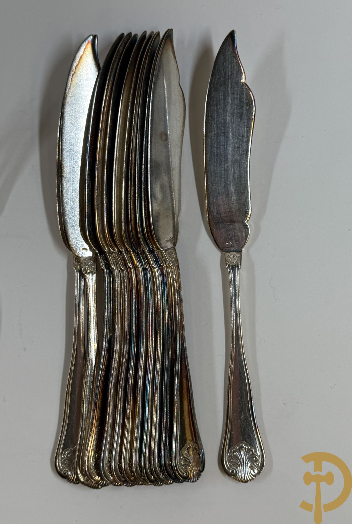 Massief zilveren bestek Wolfers bestaande uit 12 vorken (979 gram), 12 lepels (1028 gram), 11 messen, 12 visvorken (553 gram), 12 vismessen (690 gram), 12 dessertmessen, 10 koffielepels (296 gram), 12 ijslepels (369 gram), 3 botermesjes en scheplepeltje (165 gram), 5  grote stukken (samen 557 gram) waarvan slacouvert, 2 taartscheppen en wildvork + sauslepel met zelfde decor maar Metal Blanc