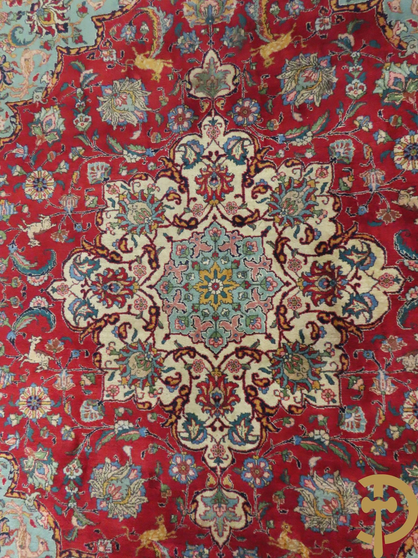 Oosters handgeknoopt tapijt met bloemen, dierenmotieven en centraal decor op rode fond