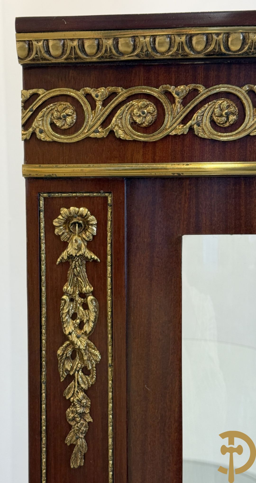 Notelaren vitrine met afgeronde zijkanten, bezet met bronzen plakkettes van dame en cupido