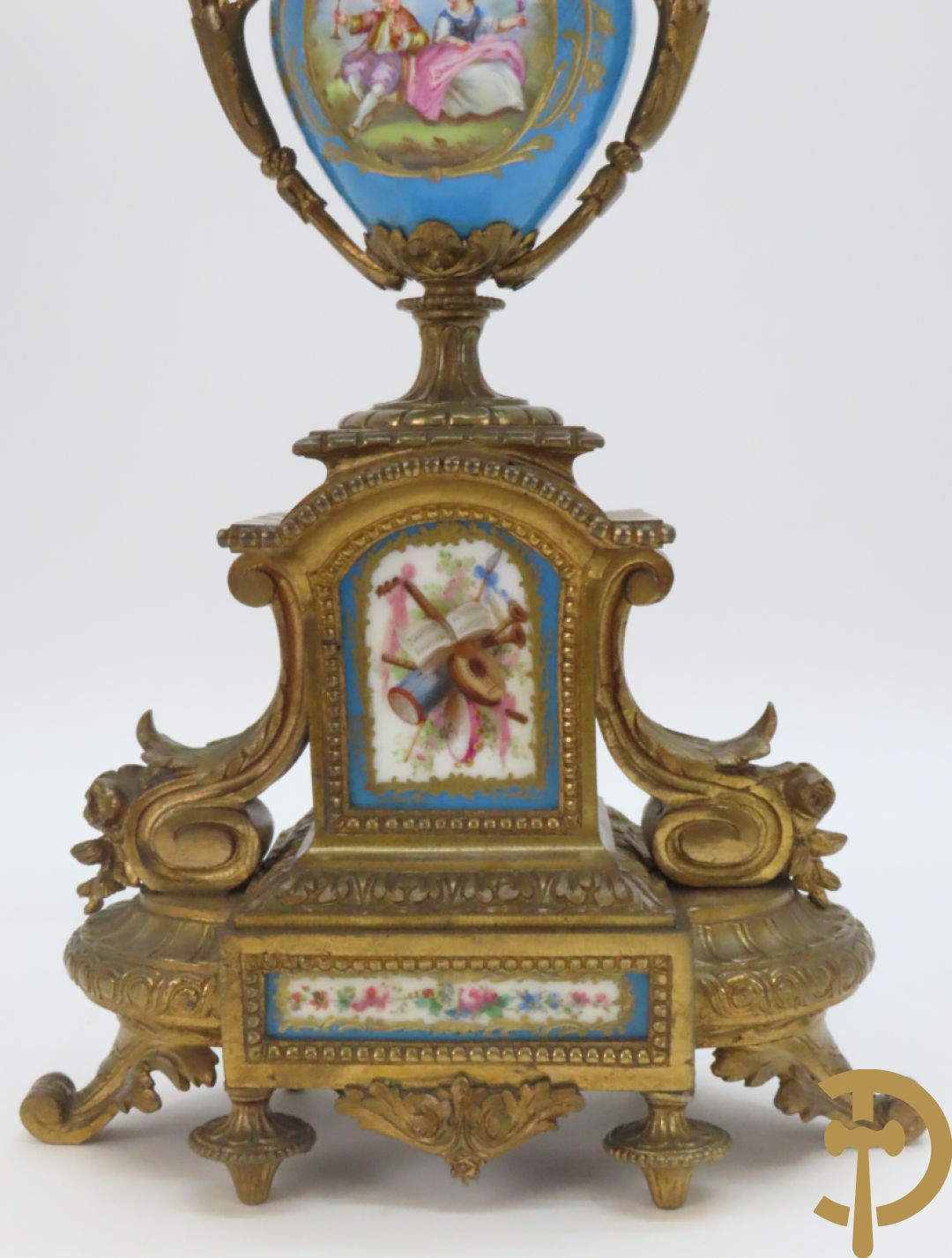 Driedelige bronzen garnituur bezet met Sèvres porselein bestaande uit pendule geflankeerd door paar cupido