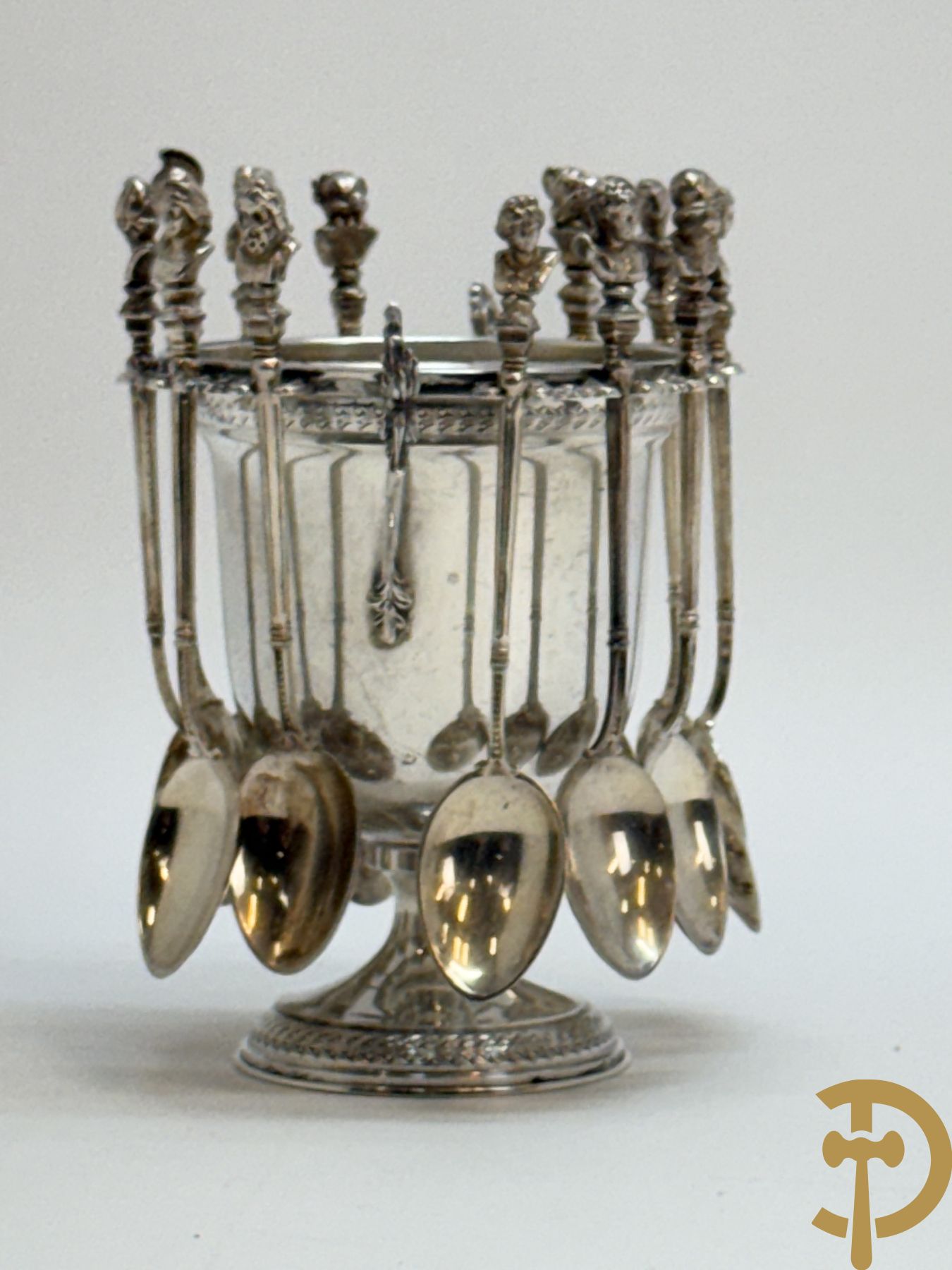 Massief zilveren suikerpot met 12 bijhorende massief zilveren lepeltjes bezet met koppen naar de antieken