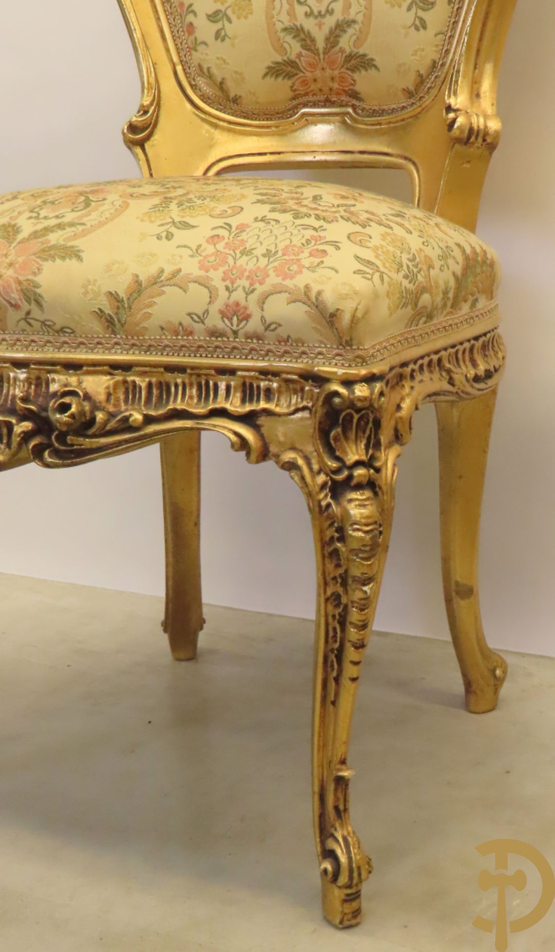 Uitzonderlijke vergulde Louis XV eetkamer bestaande uit vijfdeursdressoir met voluutvormige accanthusranken en rocailles, beschilderd met bloemenmotieven en centraal tafererel met hoornen des overvloeds + bijhorende spiegel vergulde tafel op voluutvormige poten met zes bijhorende stoelen + vitrine met accanthusranken en centrale deur, op voluutvormige poten