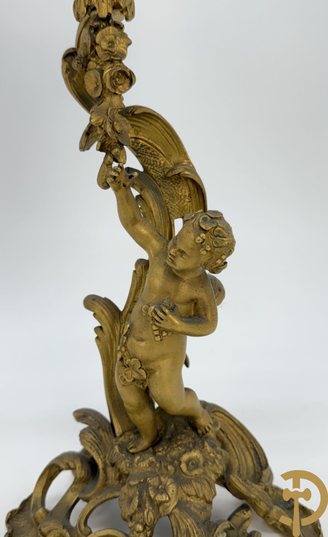 Driedelige vuurvergulde bronzen garnituur, Louis XV stijl, bestaande uit middenstuk met klok omgeven door musicerende cupido