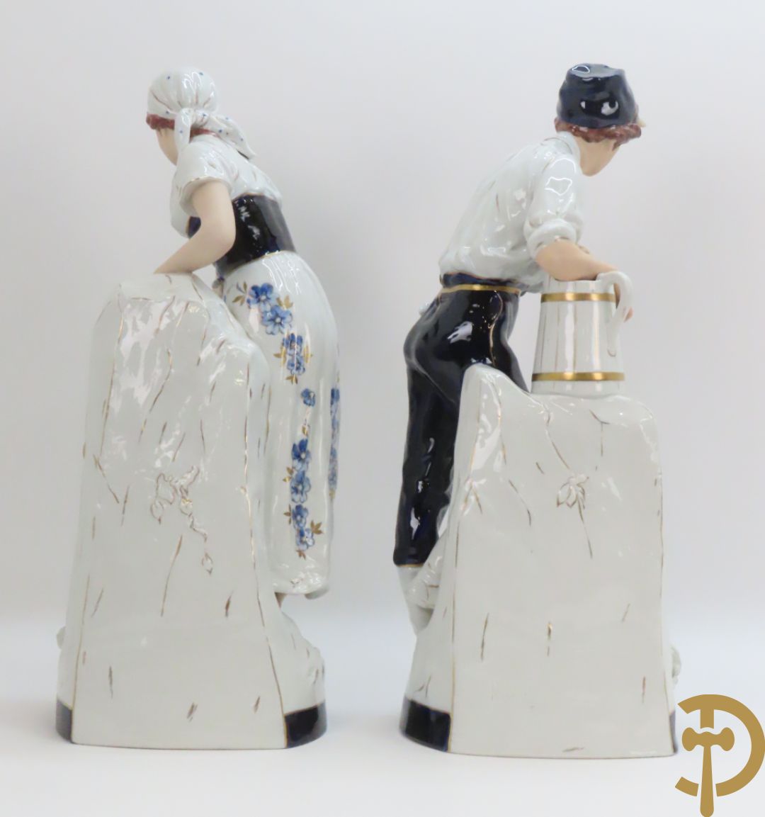 Paar Royal Dux personages van dame en heer bij de waterkraan, onderaan gemerkt en genummerd 10965 en 10563