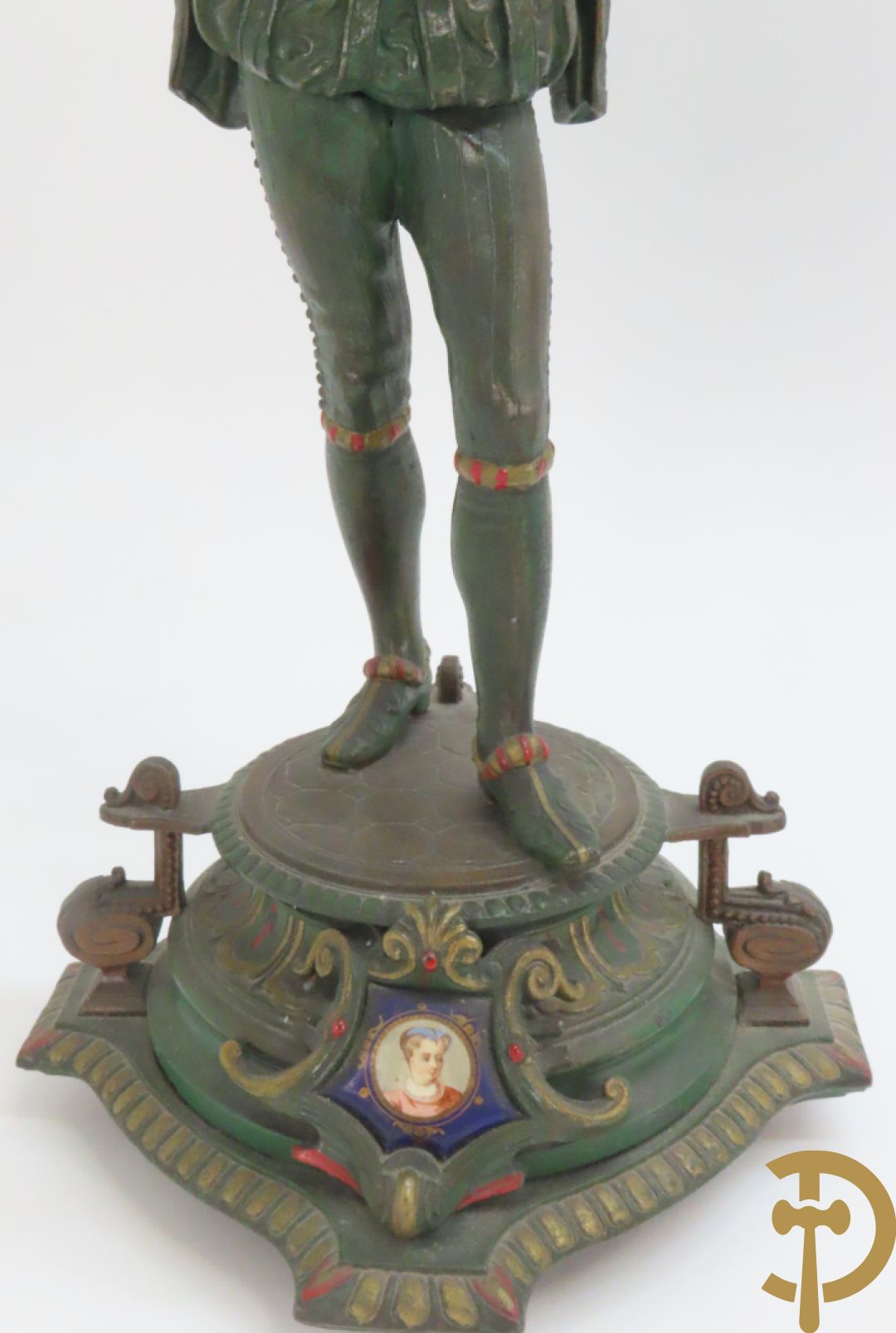 Driedelige kunstbronzen garnituur bestaande uit pendule met paar schakende edelheren, bezet met kariatiden - geflankeerd door paar driearmige kandelaars gehouden door 2 edelheren