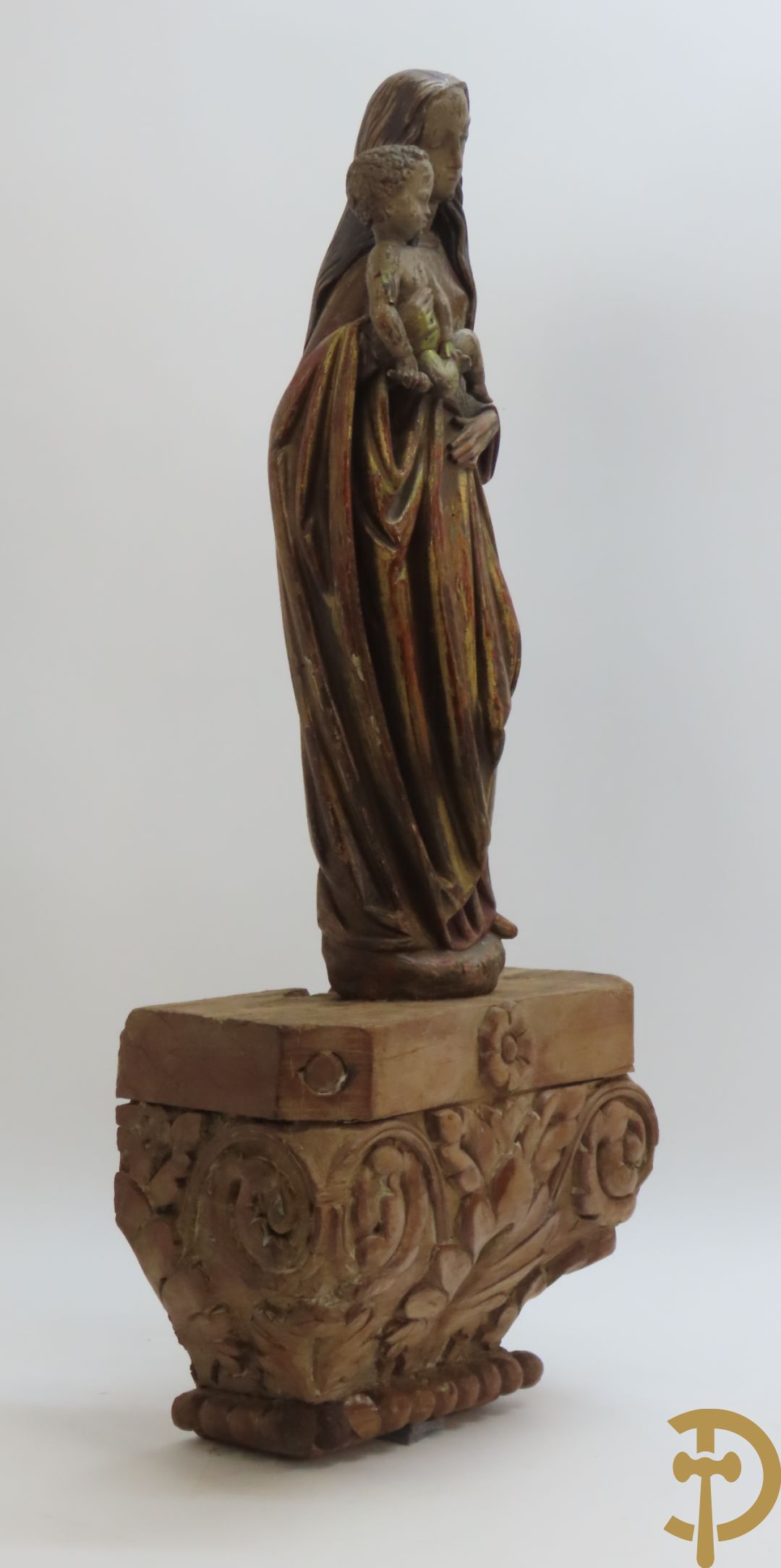 Gepolychromeerde houtsculptuur van madonna met kind gemonteerd op sokkel met accanthusranken