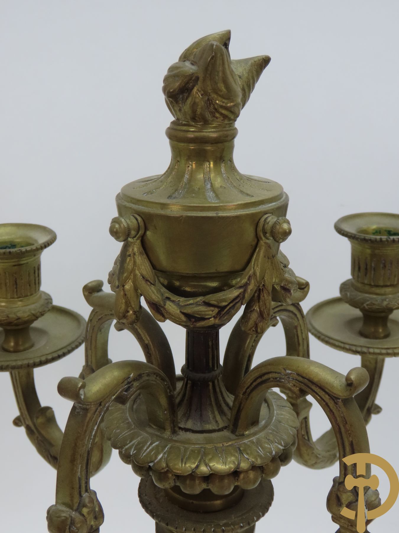 Paar bronzen Louis XVI vierarmige kandelaars bezet met toorts bovenaan