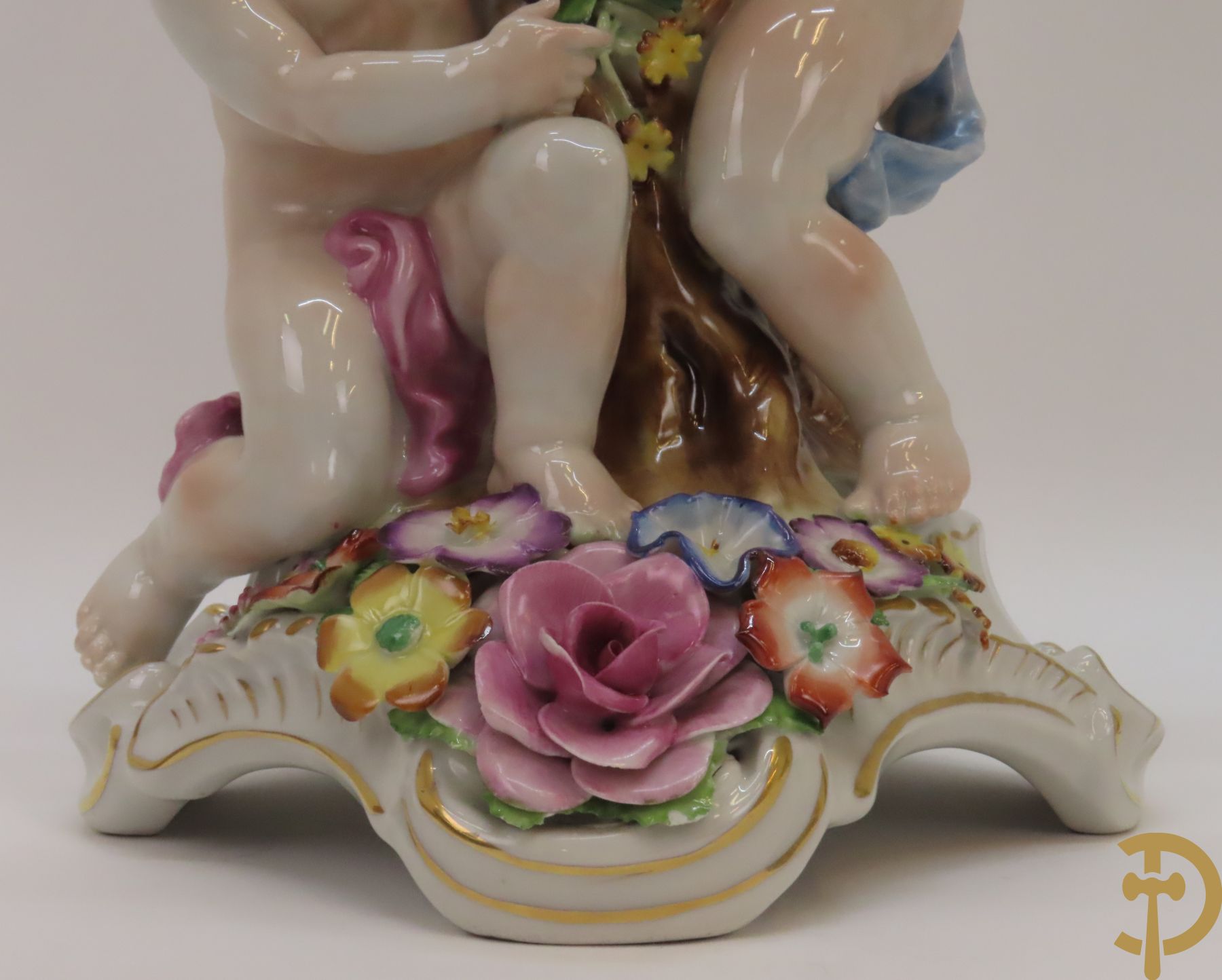 Twee porseleinen vijfarmige kandelaars met cupido