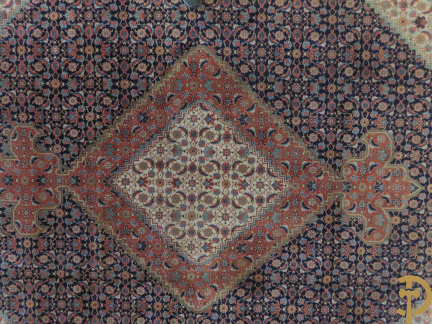 Oosters handgeknoopt tapijt met centraal decor op blauwe fond met bloemenmotieven