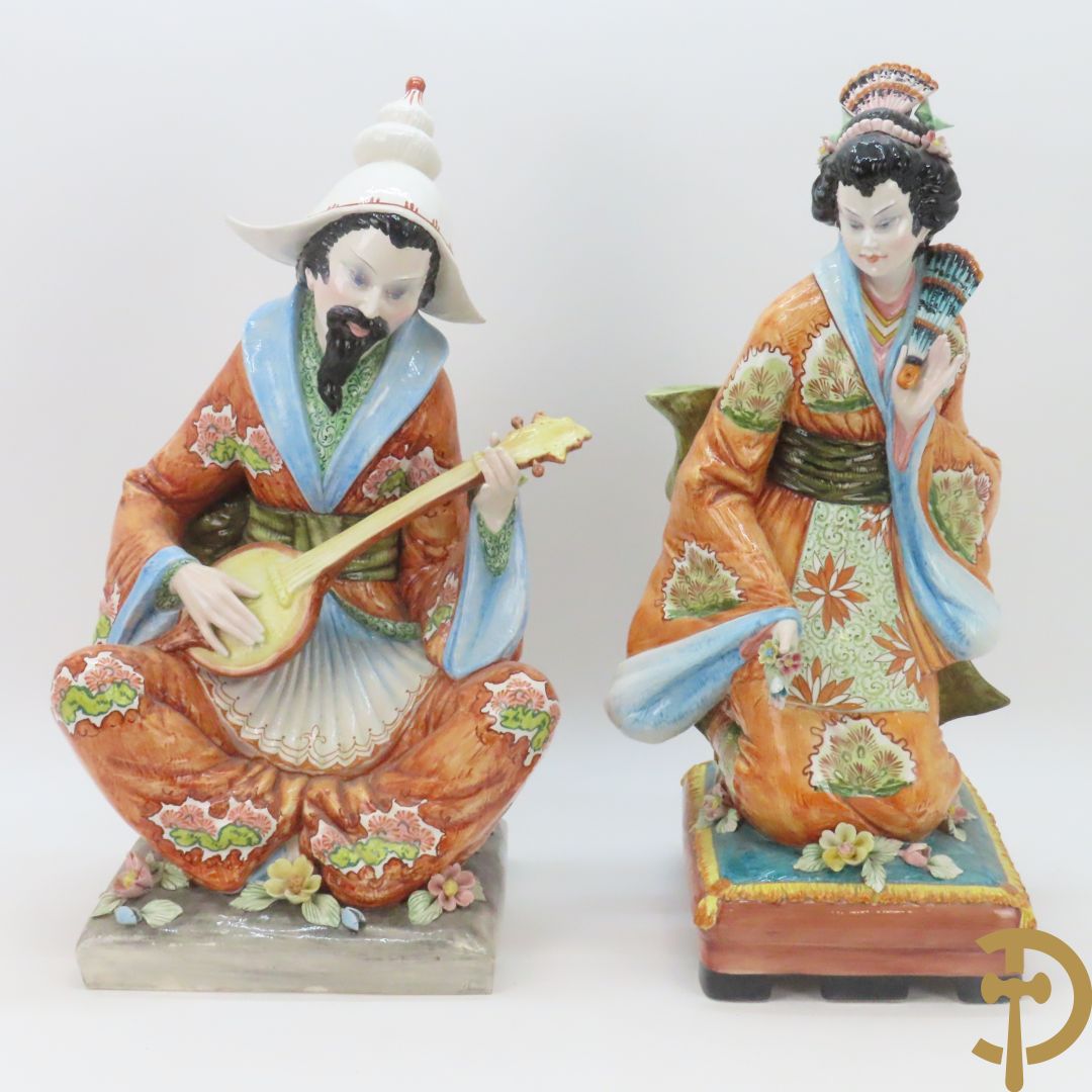 Twee Italiaanse beelden van oosterse dame met bloemen, getekend achteraan Polouioto en oosterse man met snaarinstrument in meerkleurige faience