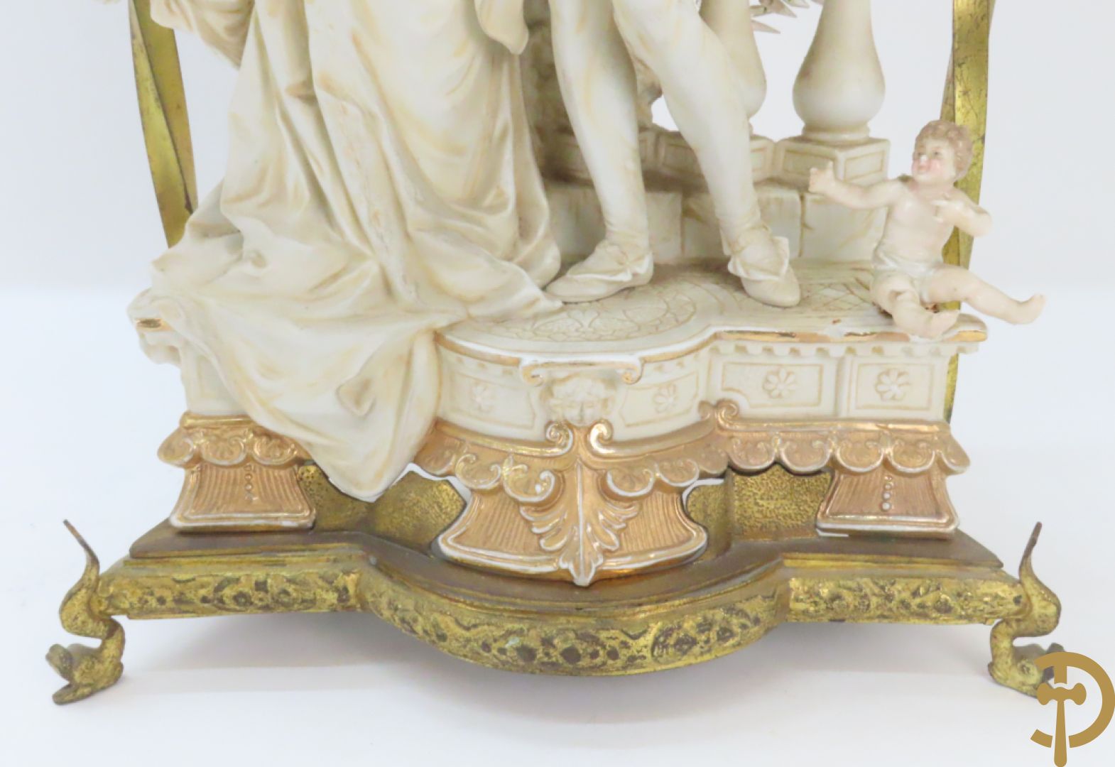 Lieftallig biscuit van romantisch koppel bij amfoor met kleine neergezeten cupido onder koperen baldakijn met kristallen belletjes