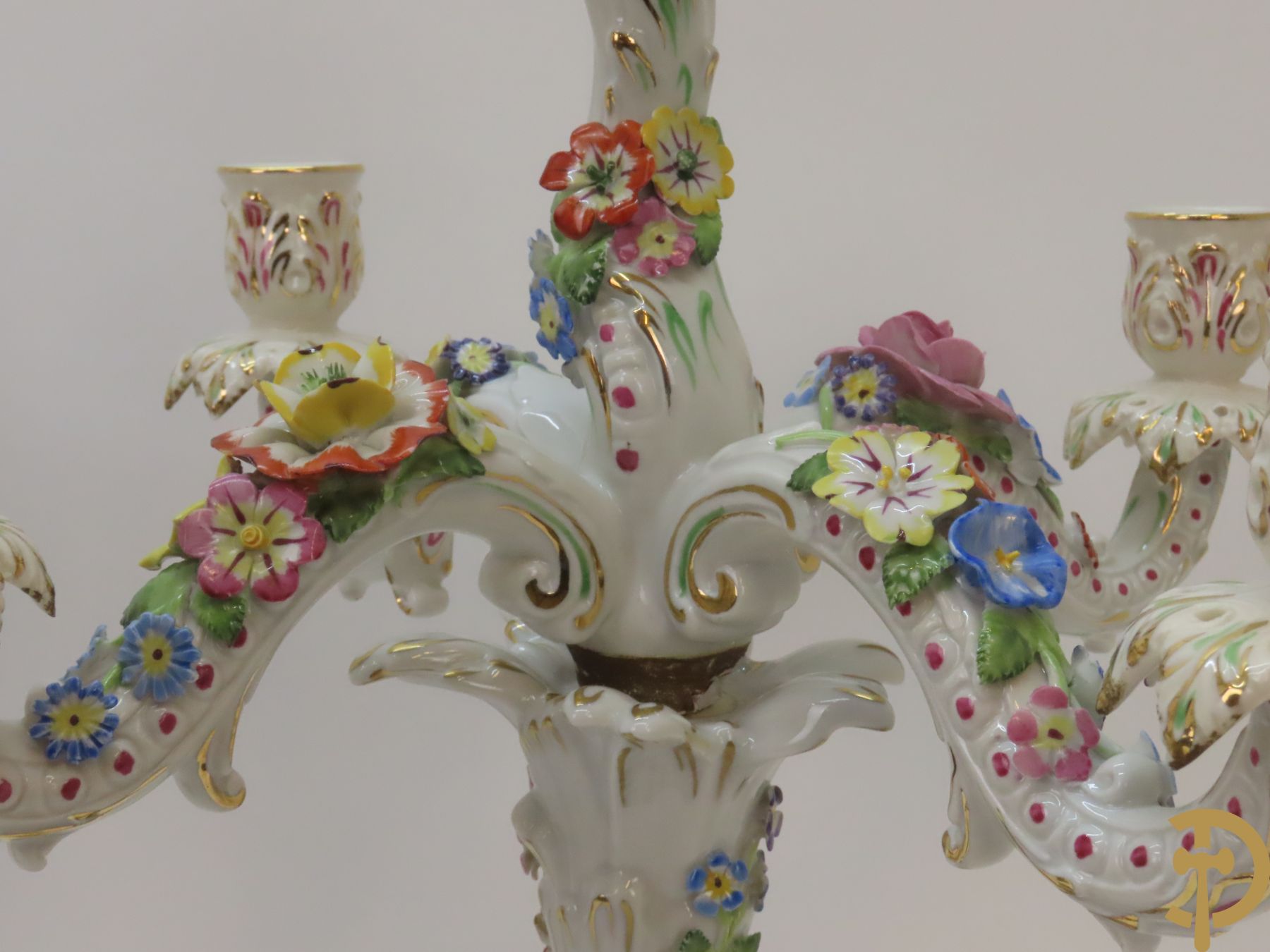 Twee porseleinen vijfarmige kandelaars met cupido