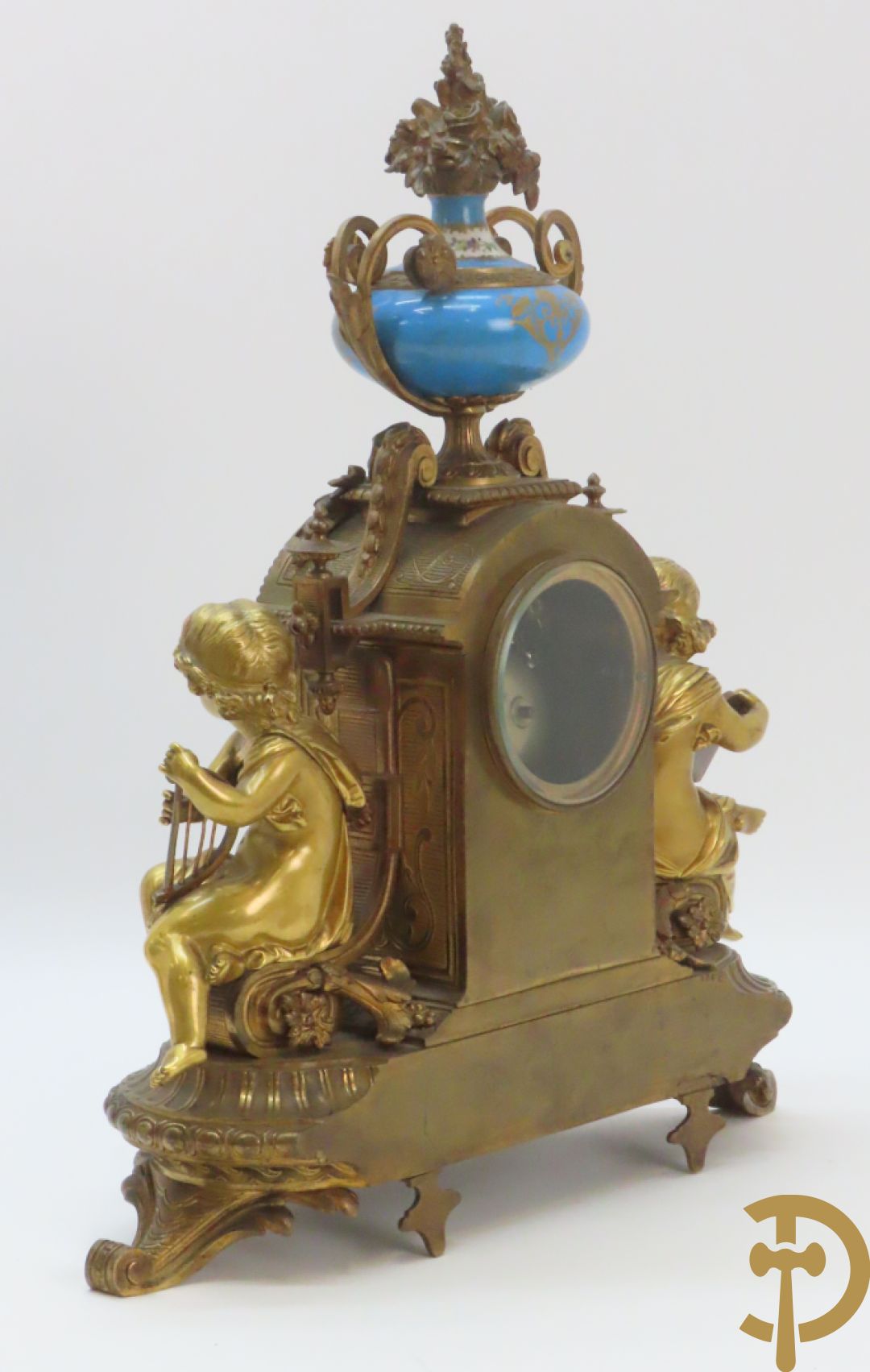 Driedelige bronzen garnituur bezet met Sèvres porselein bestaande uit pendule geflankeerd door paar cupido