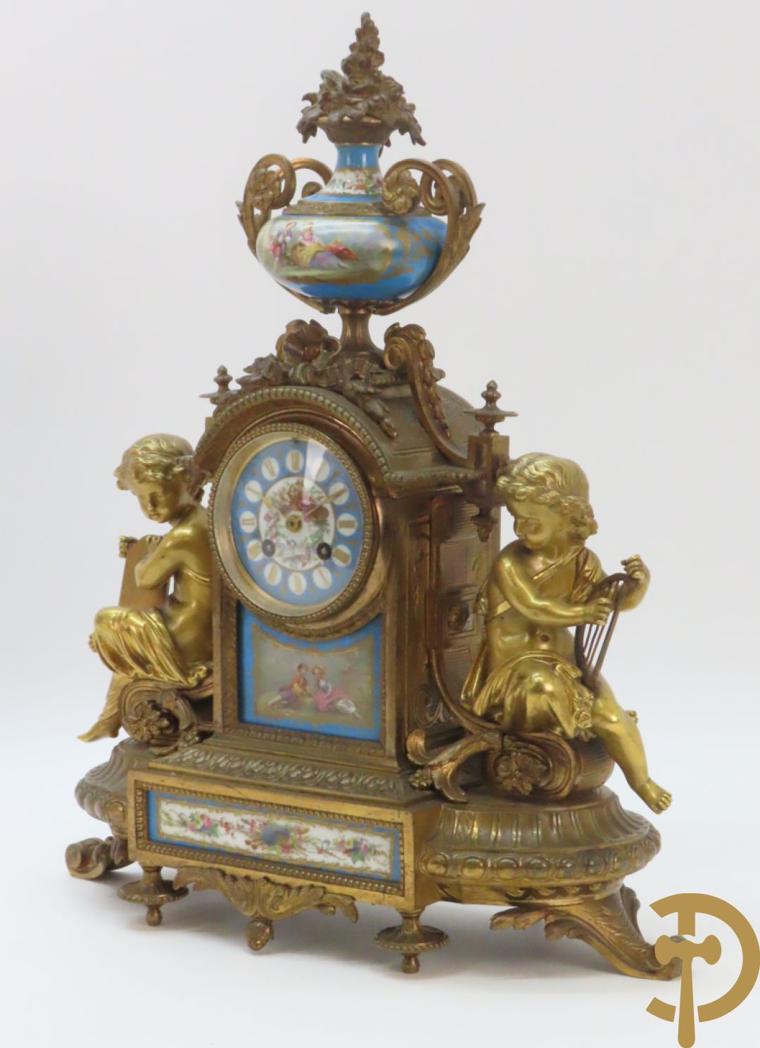 Driedelige bronzen garnituur bezet met Sèvres porselein bestaande uit pendule geflankeerd door paar cupido