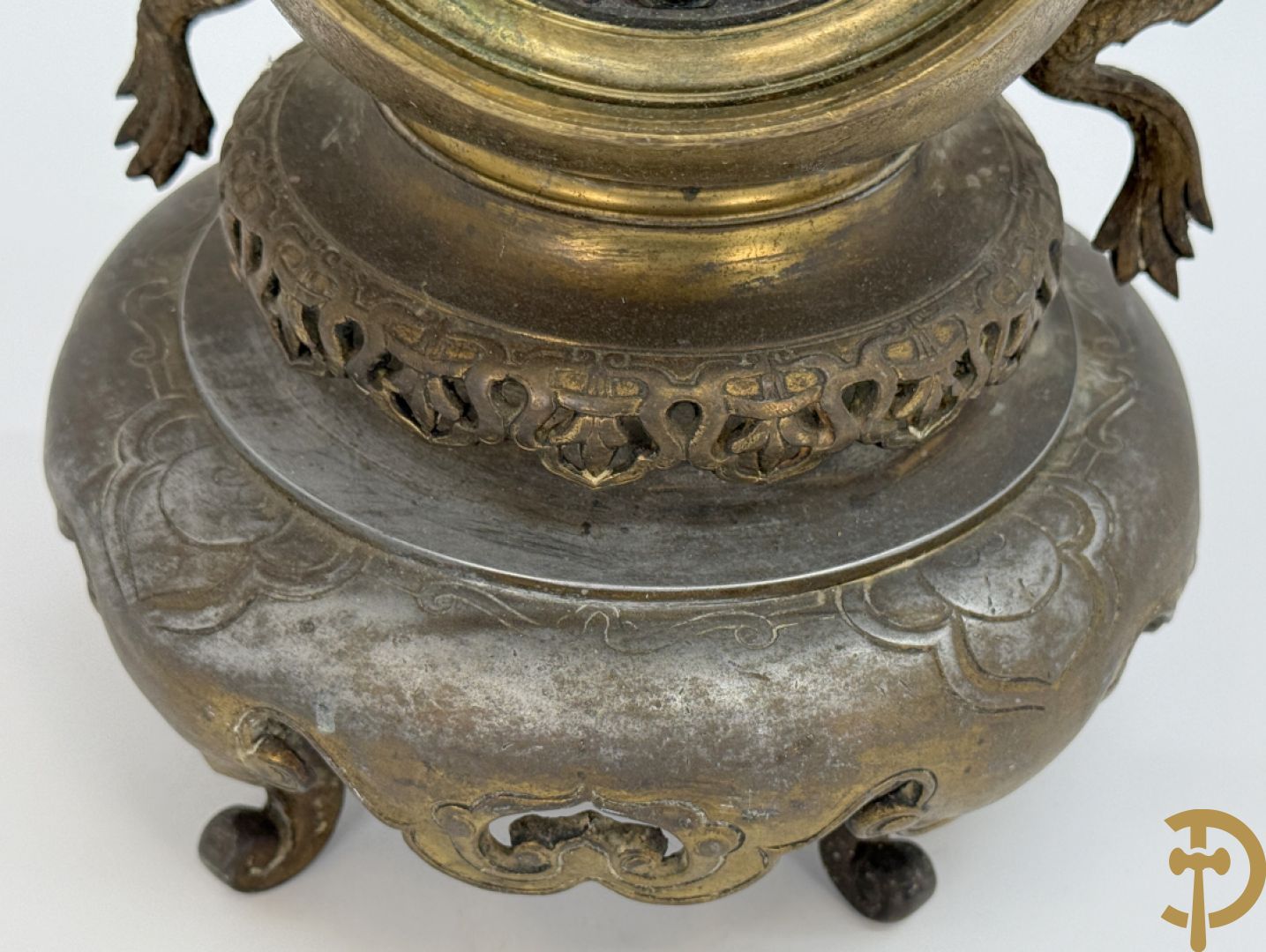 Aziatische pendule in zamak, zijdelings bezet met drakendecor en bovenaan met mythologisch figuur