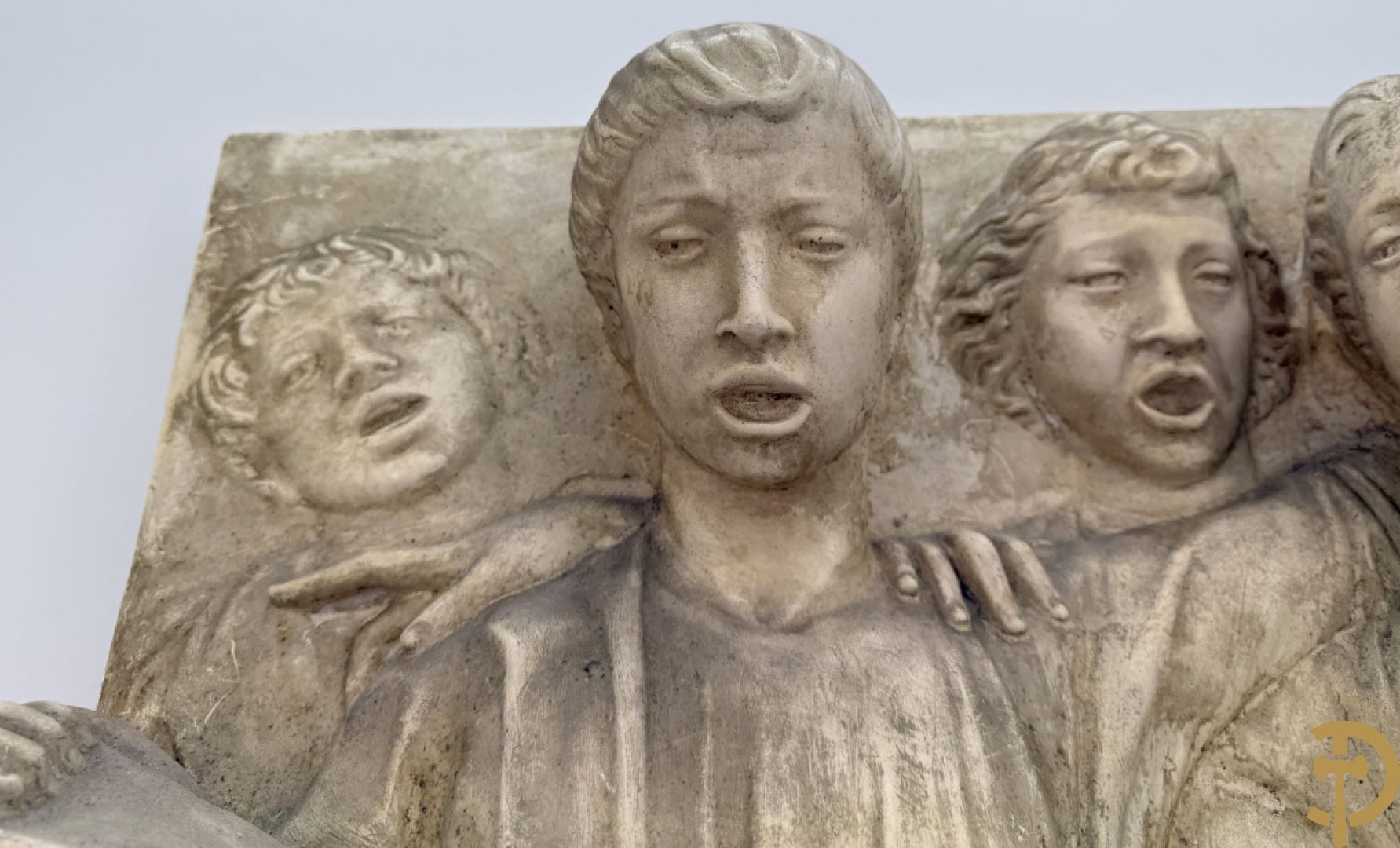 Gipsen basrelief met een zingend jongerenkoor