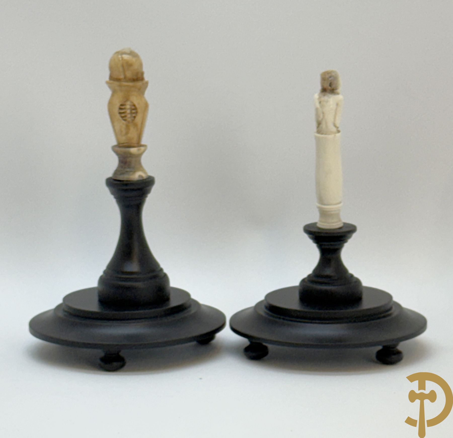 Twee handgesculpteerde hertegeweien in de vorm van een doodskop onder globe