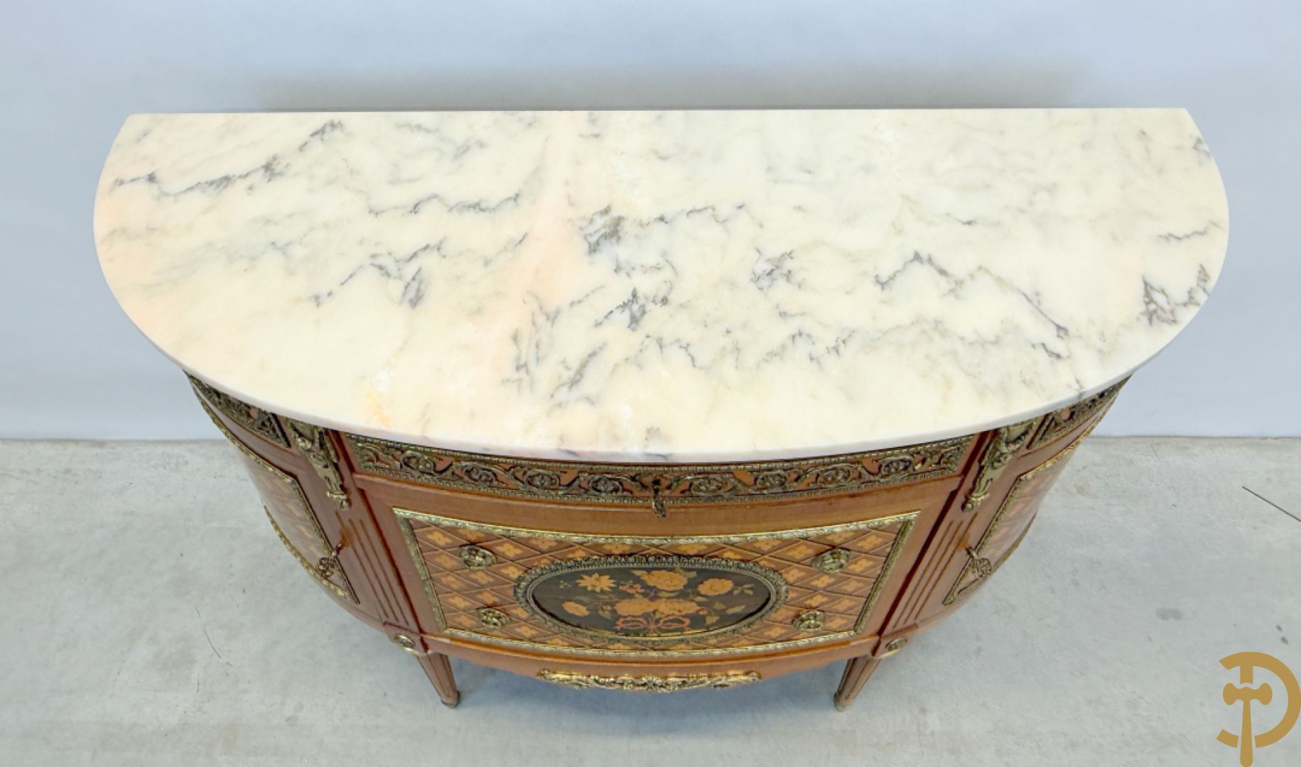 Halve maanvormige drieladencommode met 2 zijdelingse deuren, gemarketteerde bloemenmotieven en bronzen ornamenten, bovenaan bezet met marmeren blad