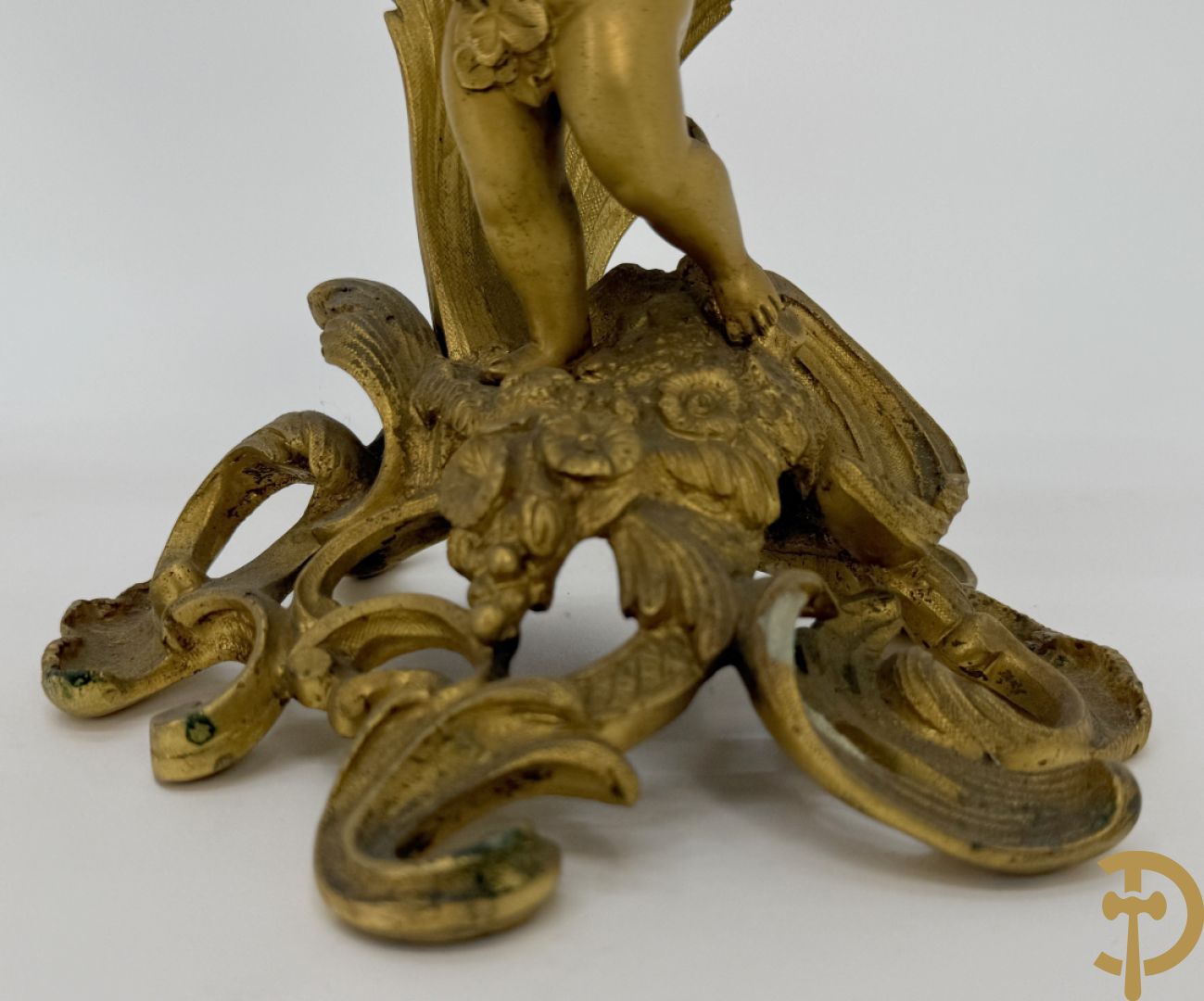 Driedelige vuurvergulde bronzen garnituur, Louis XV stijl, bestaande uit middenstuk met klok omgeven door musicerende cupido