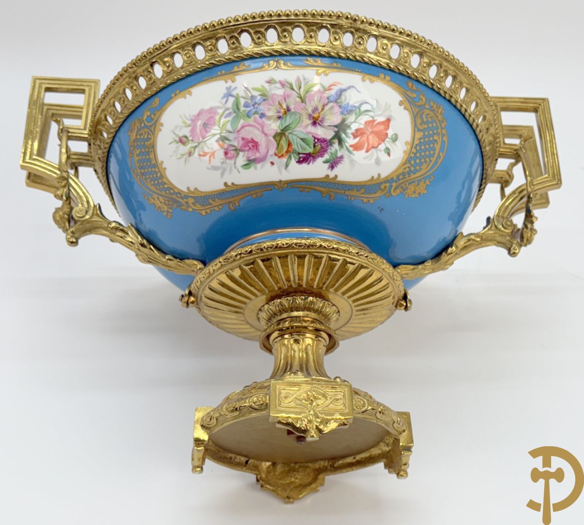 Porseleinen coupe met centraal tafereel en omringd met bloemendecor, gevat in bronzen houder
