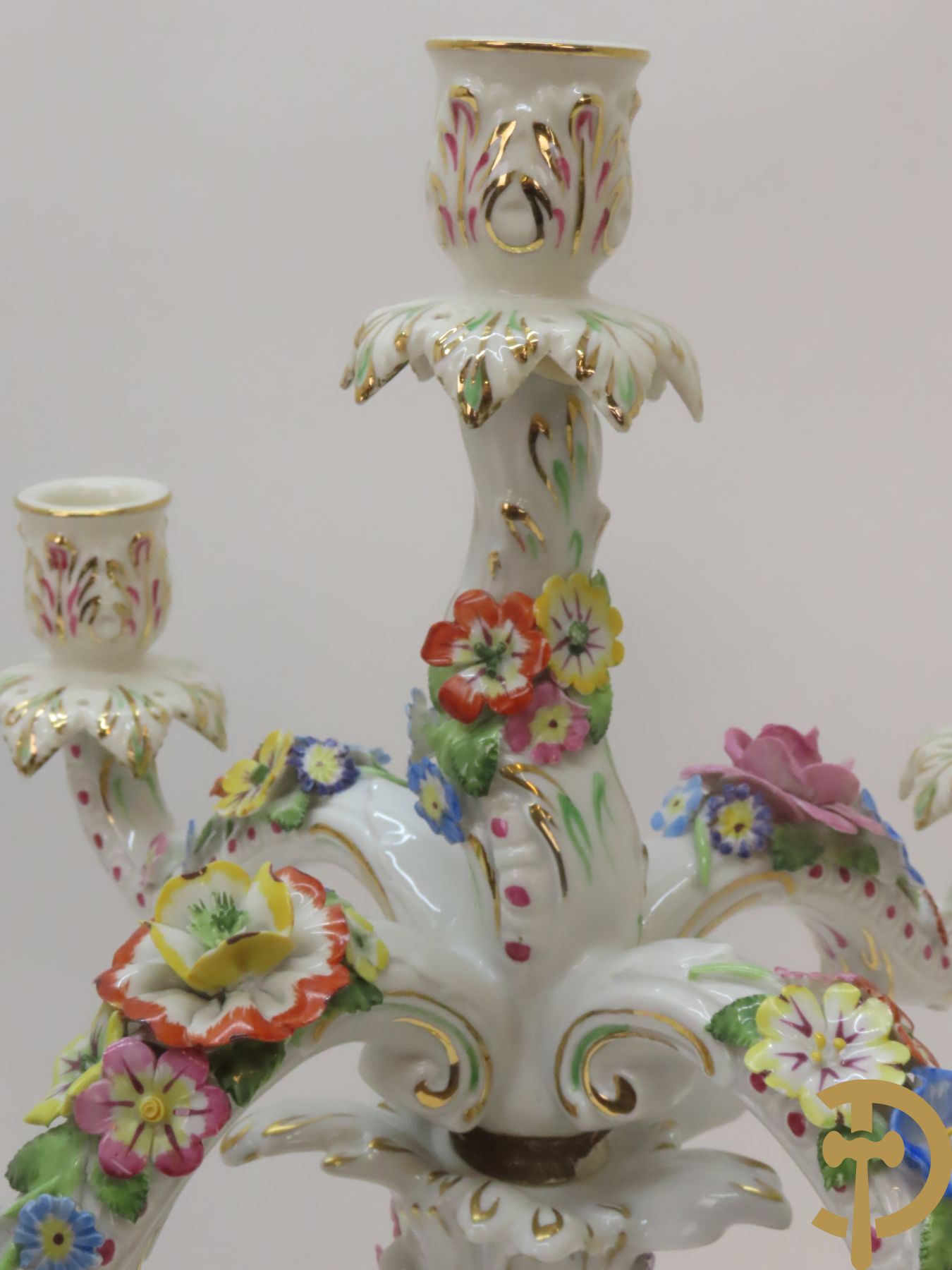 Twee porseleinen vijfarmige kandelaars met cupido