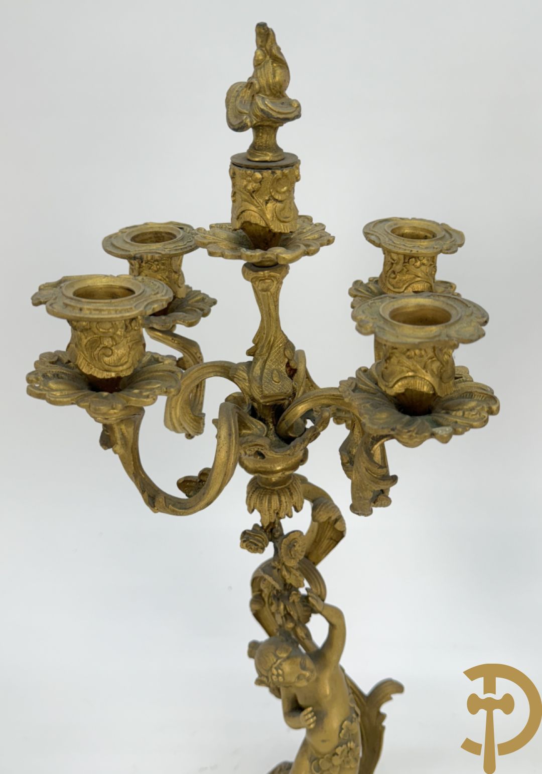 Driedelige vuurvergulde bronzen garnituur, Louis XV stijl, bestaande uit middenstuk met klok omgeven door musicerende cupido