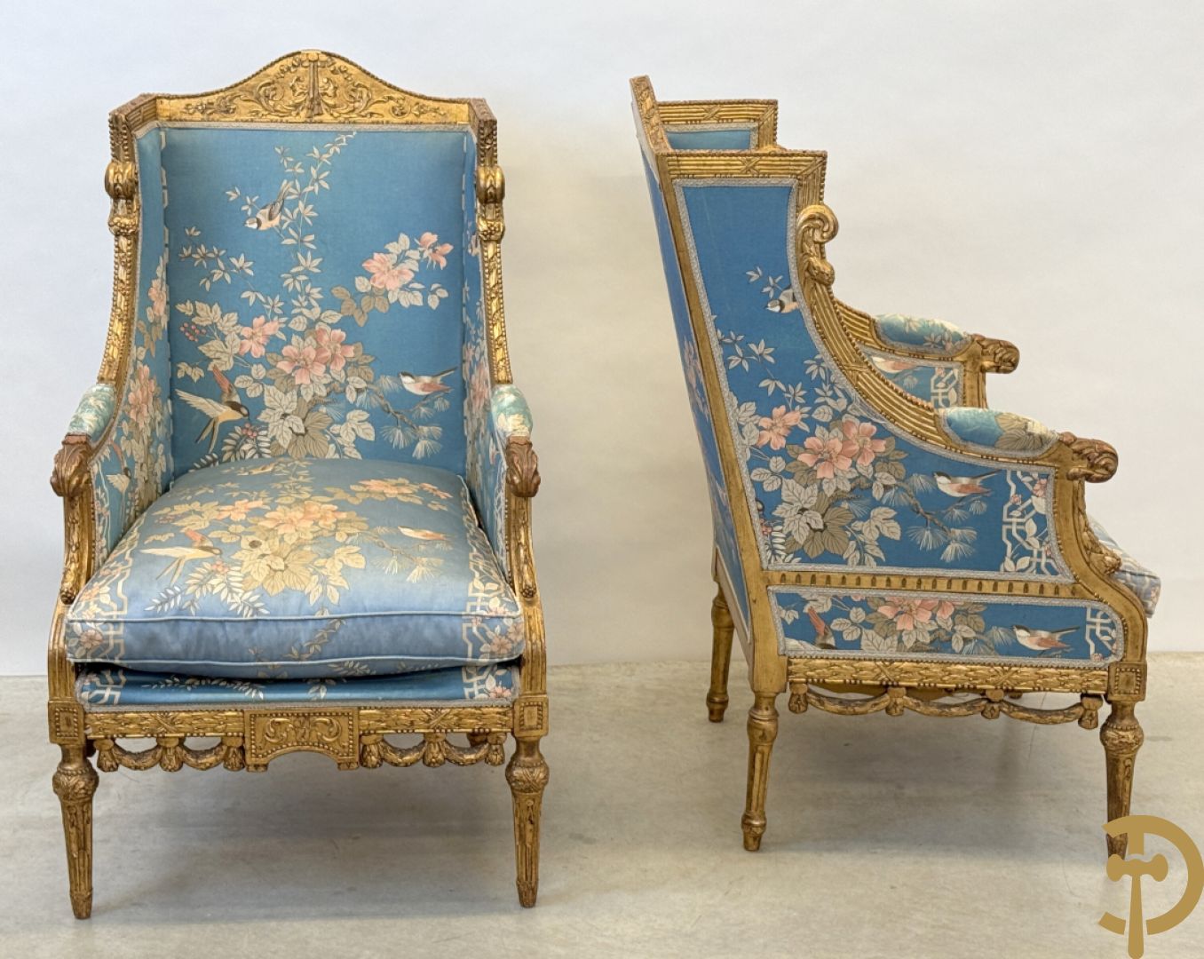 Twee vergulde bergères met gesculpteerde accanthusranken en guirlandes