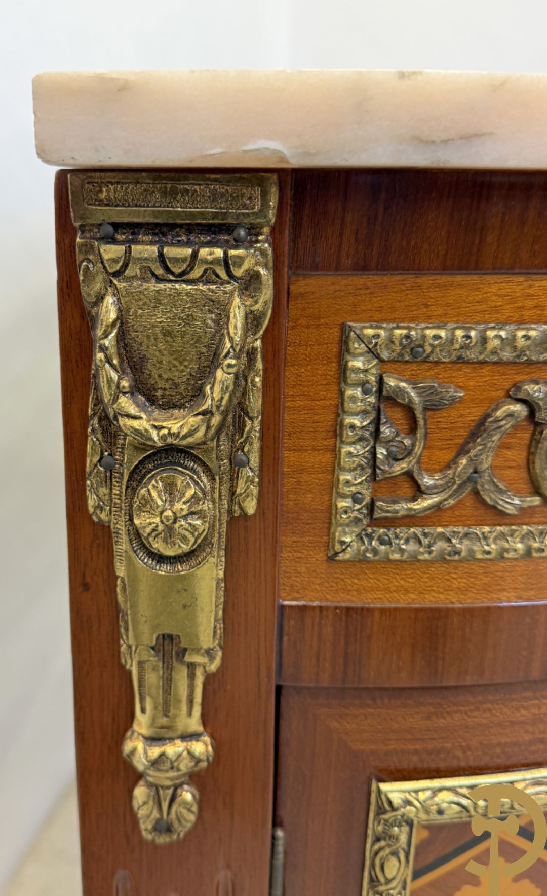 Halve maanvormige drieladencommode met 2 zijdelingse deuren, gemarketteerde bloemenmotieven en bronzen ornamenten, bovenaan bezet met marmeren blad