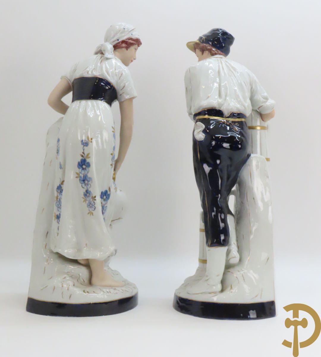 Paar Royal Dux personages van dame en heer bij de waterkraan, onderaan gemerkt en genummerd 10965 en 10563
