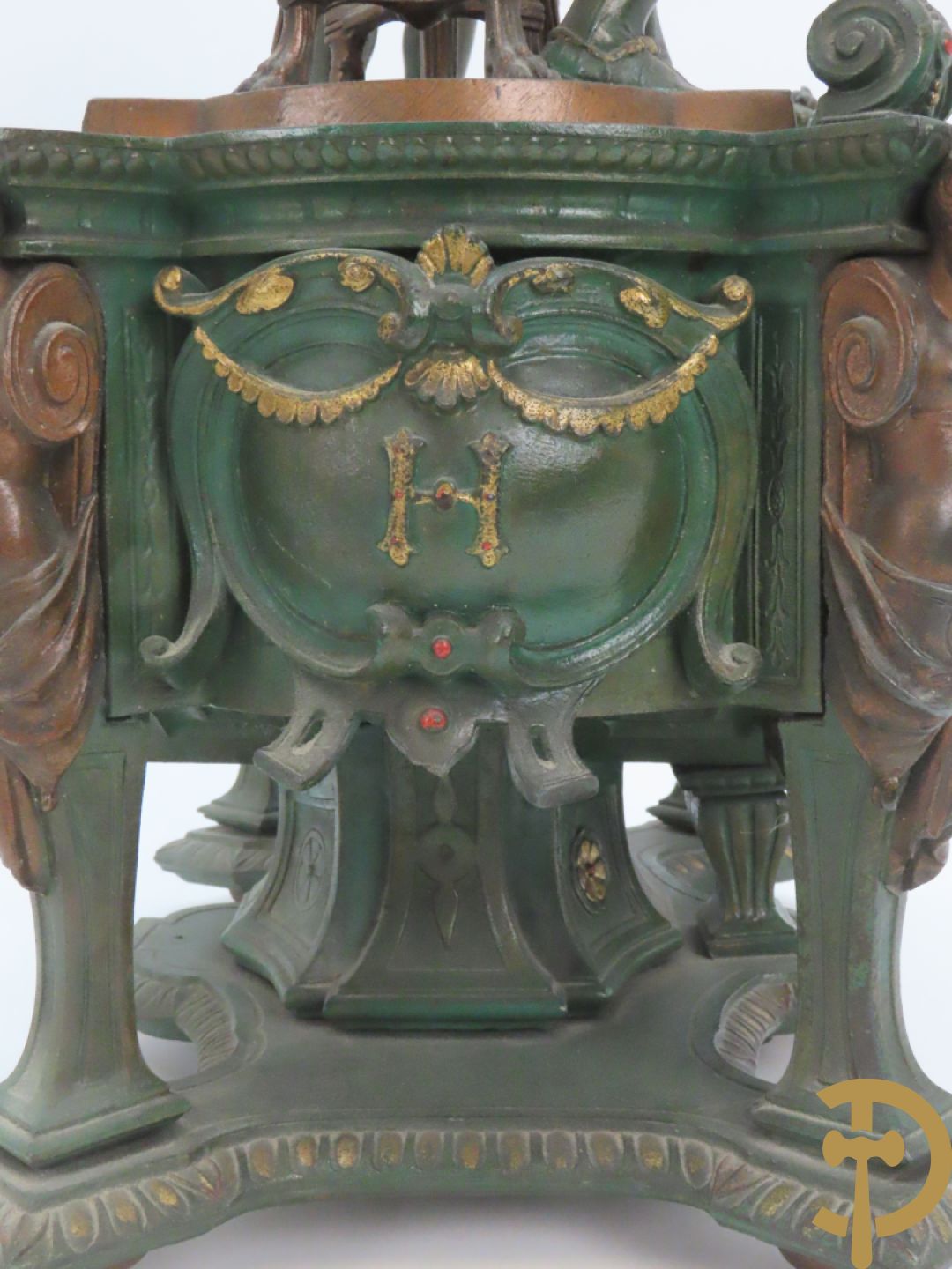 Driedelige kunstbronzen garnituur bestaande uit pendule met paar schakende edelheren, bezet met kariatiden - geflankeerd door paar driearmige kandelaars gehouden door 2 edelheren