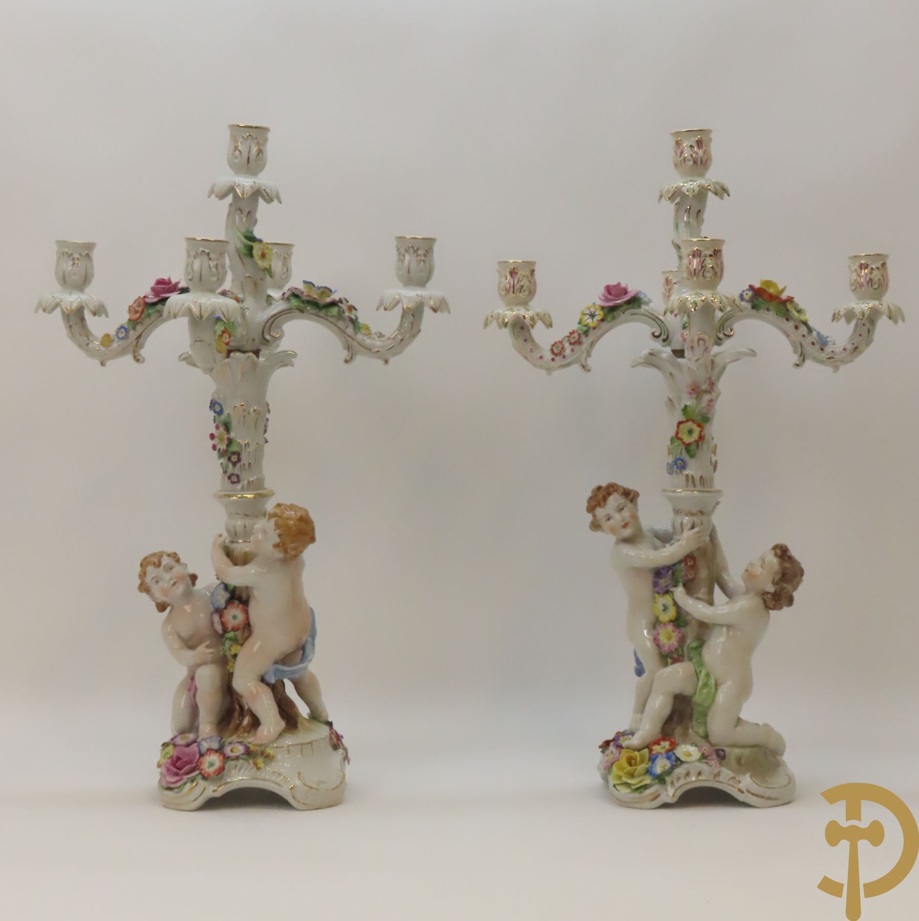 Twee porseleinen vijfarmige kandelaars met cupido