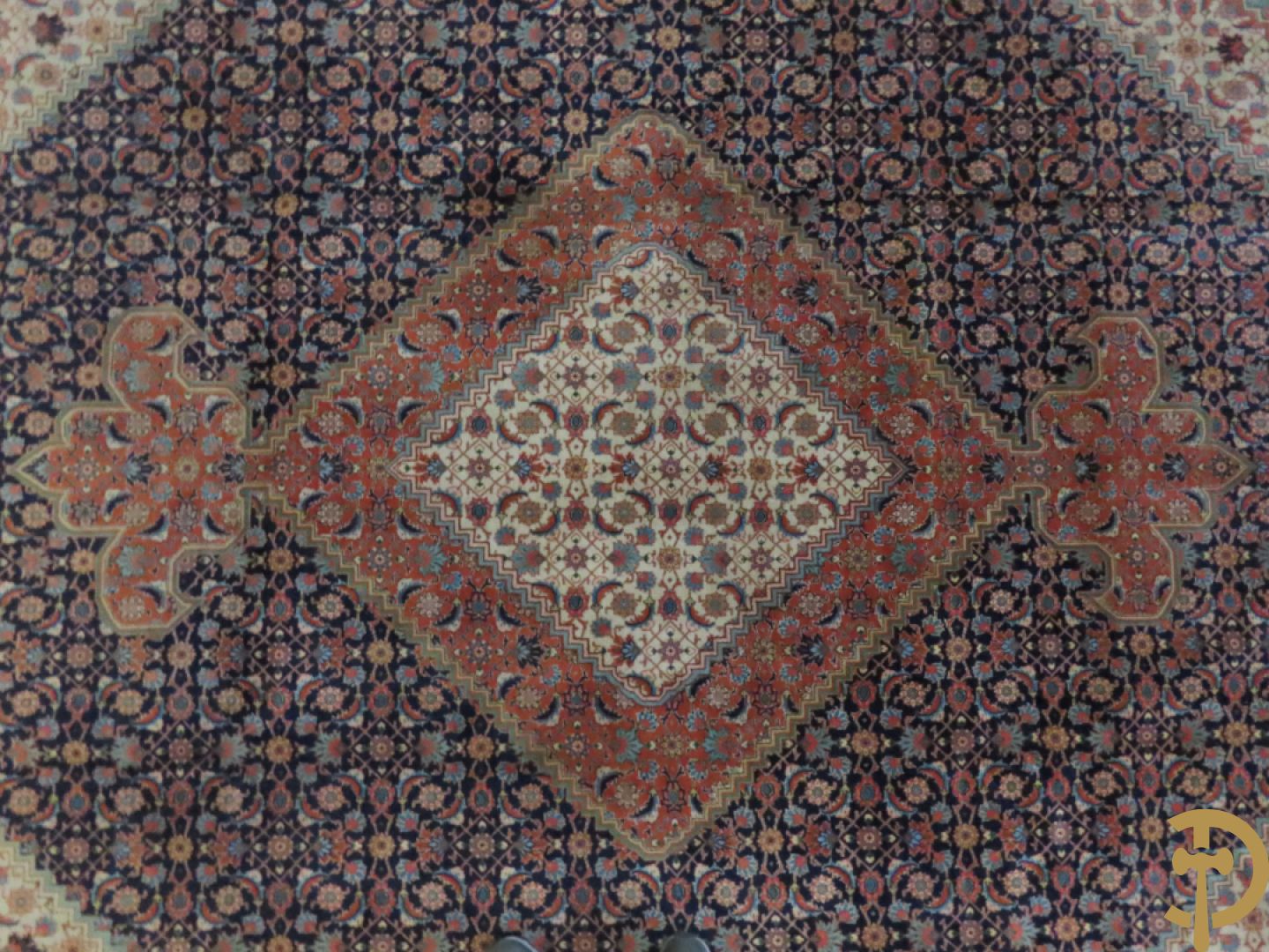 Oosters handgeknoopt tapijt met centraal decor op blauwe fond met bloemenmotieven