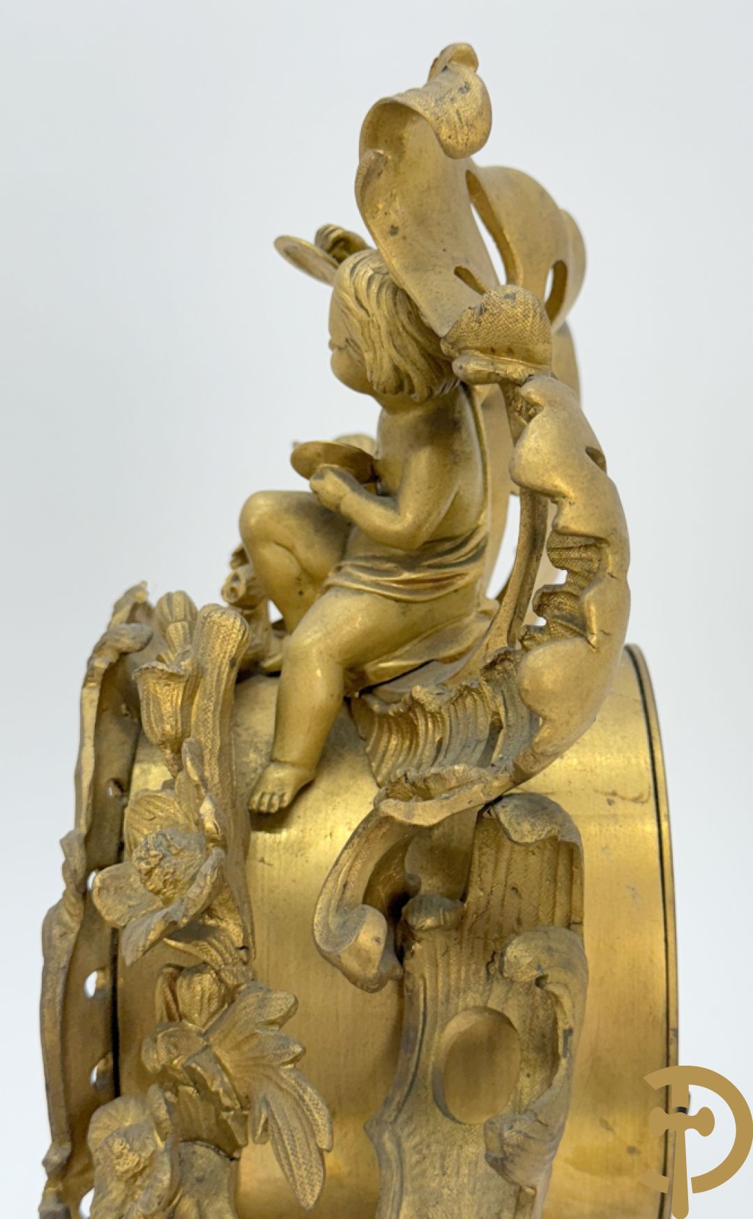 Driedelige vuurvergulde bronzen garnituur, Louis XV stijl, bestaande uit middenstuk met klok omgeven door musicerende cupido