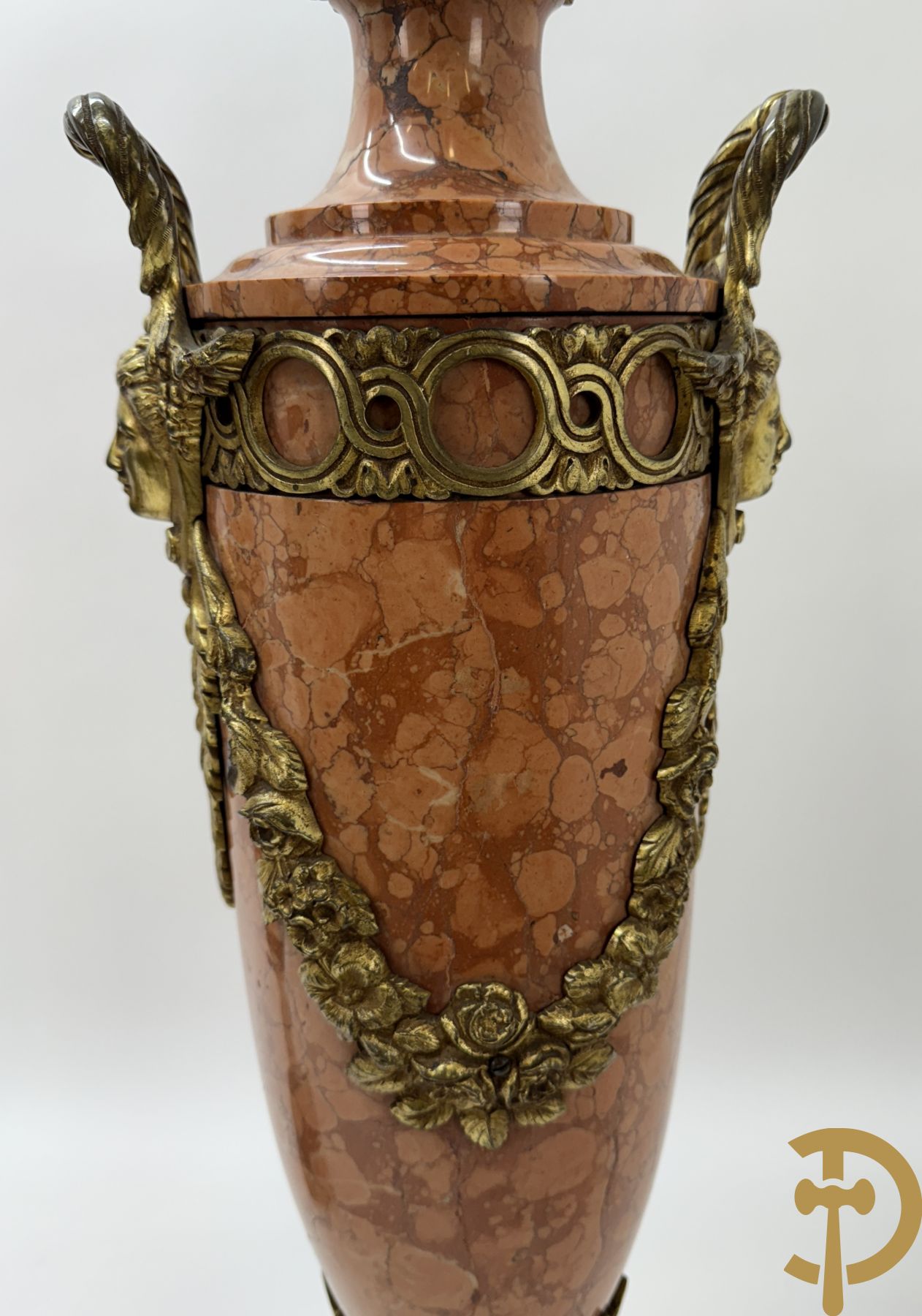 Paar oranje/rode marmeren cassolettes, zijdelings bezet met dameshoofden dragende een guirlande van bloemen - bovenaan met bloementroffee