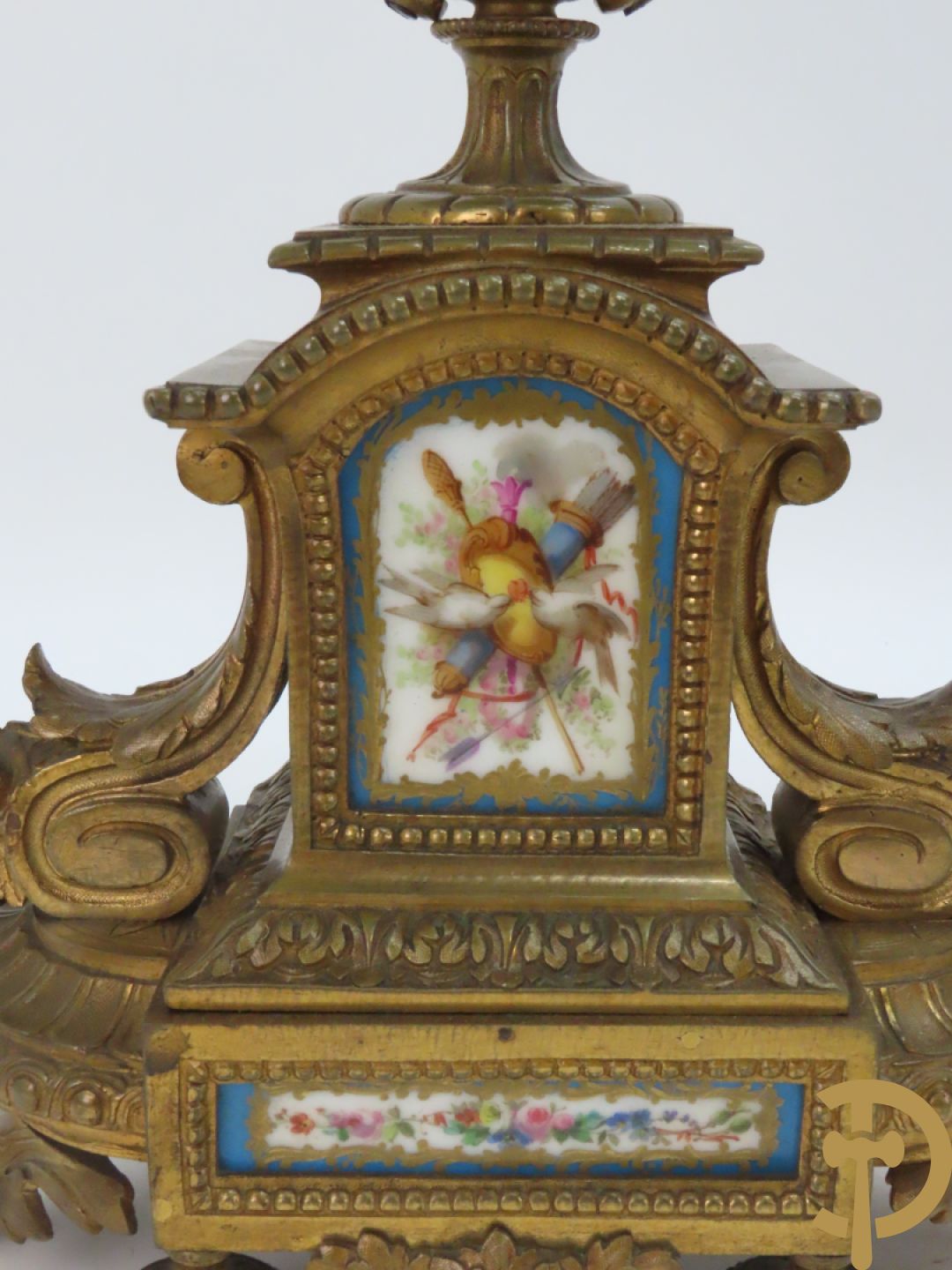 Driedelige bronzen garnituur bezet met Sèvres porselein bestaande uit pendule geflankeerd door paar cupido