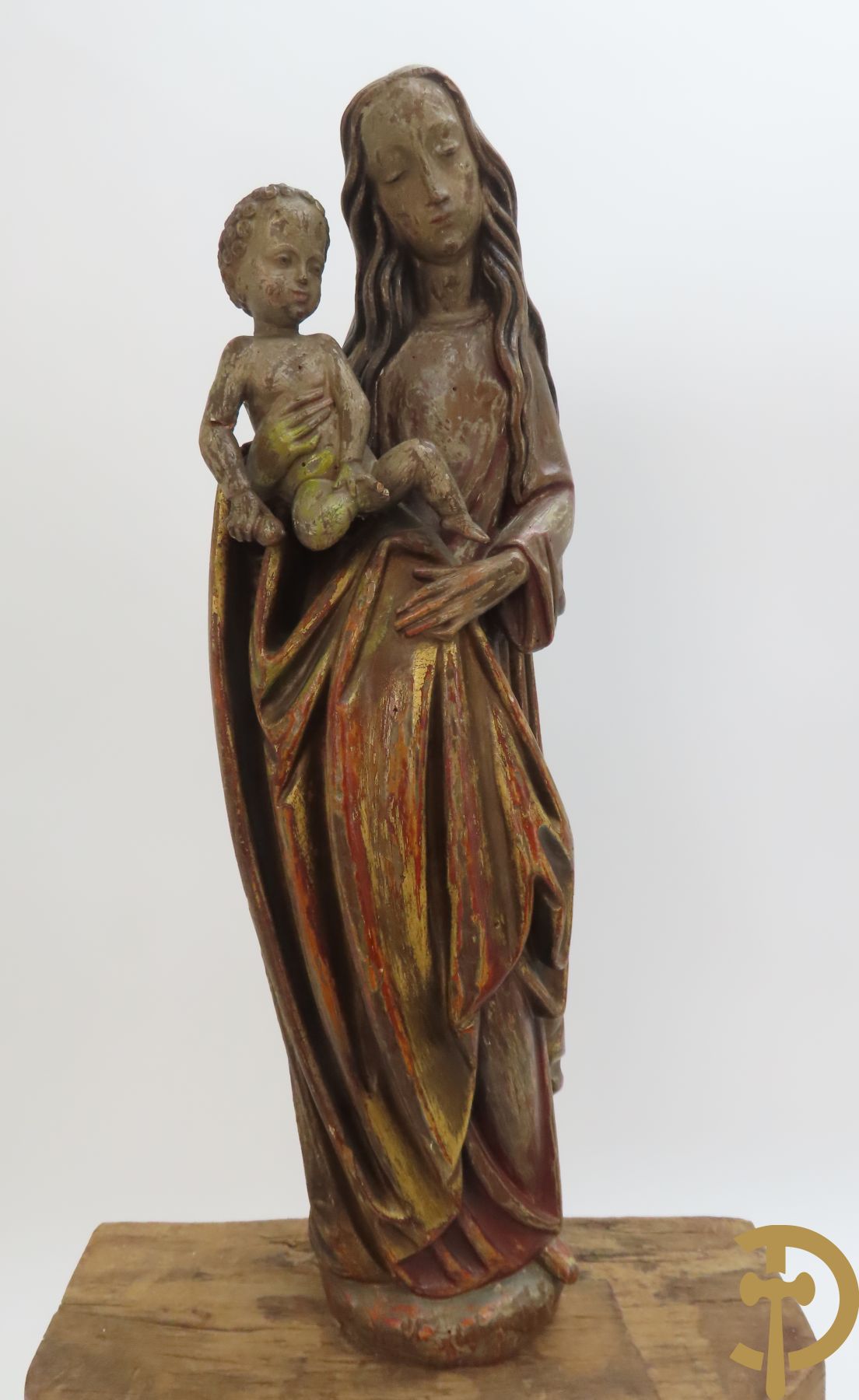 Gepolychromeerde houtsculptuur van madonna met kind gemonteerd op sokkel met accanthusranken