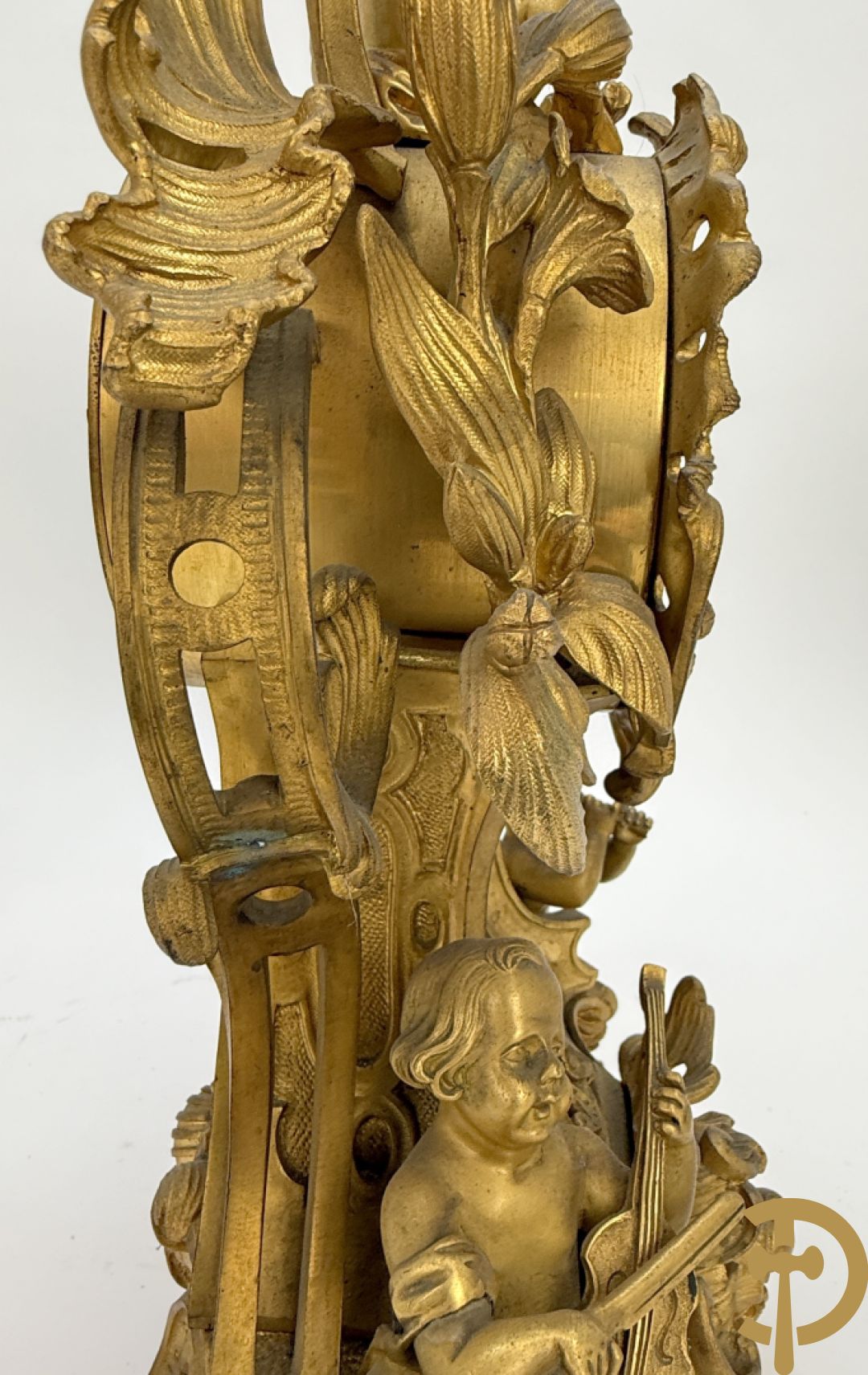 Driedelige vuurvergulde bronzen garnituur, Louis XV stijl, bestaande uit middenstuk met klok omgeven door musicerende cupido