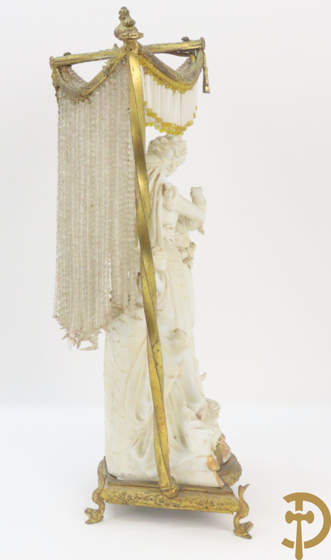 Lieftallig biscuit van romantisch koppel bij amfoor met kleine neergezeten cupido onder koperen baldakijn met kristallen belletjes